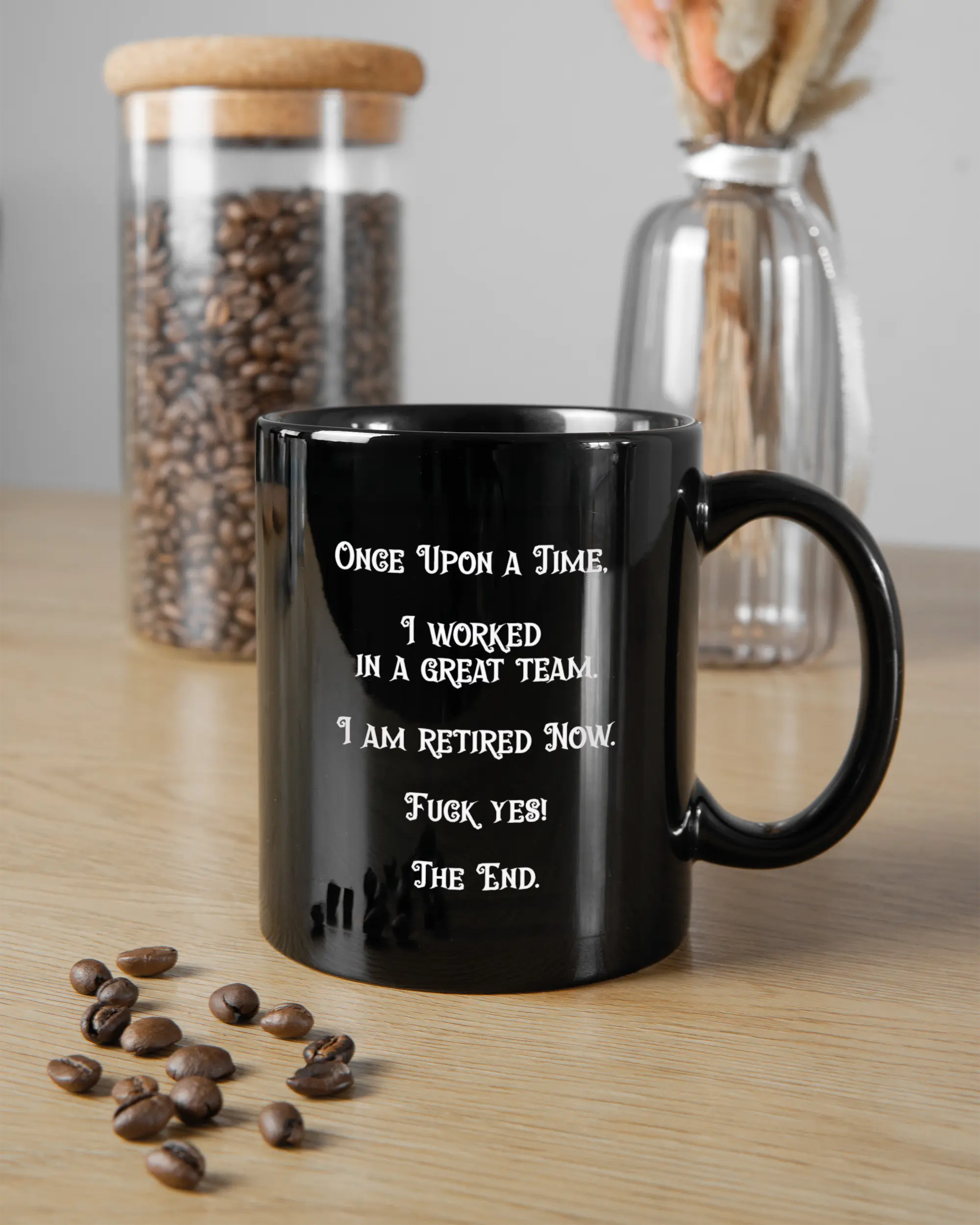 Küchentischansicht der rechten Seite der beidseitig bedruckten Keramiktasse von Maondo mit dem Design Finally Retired in der Farbe Black