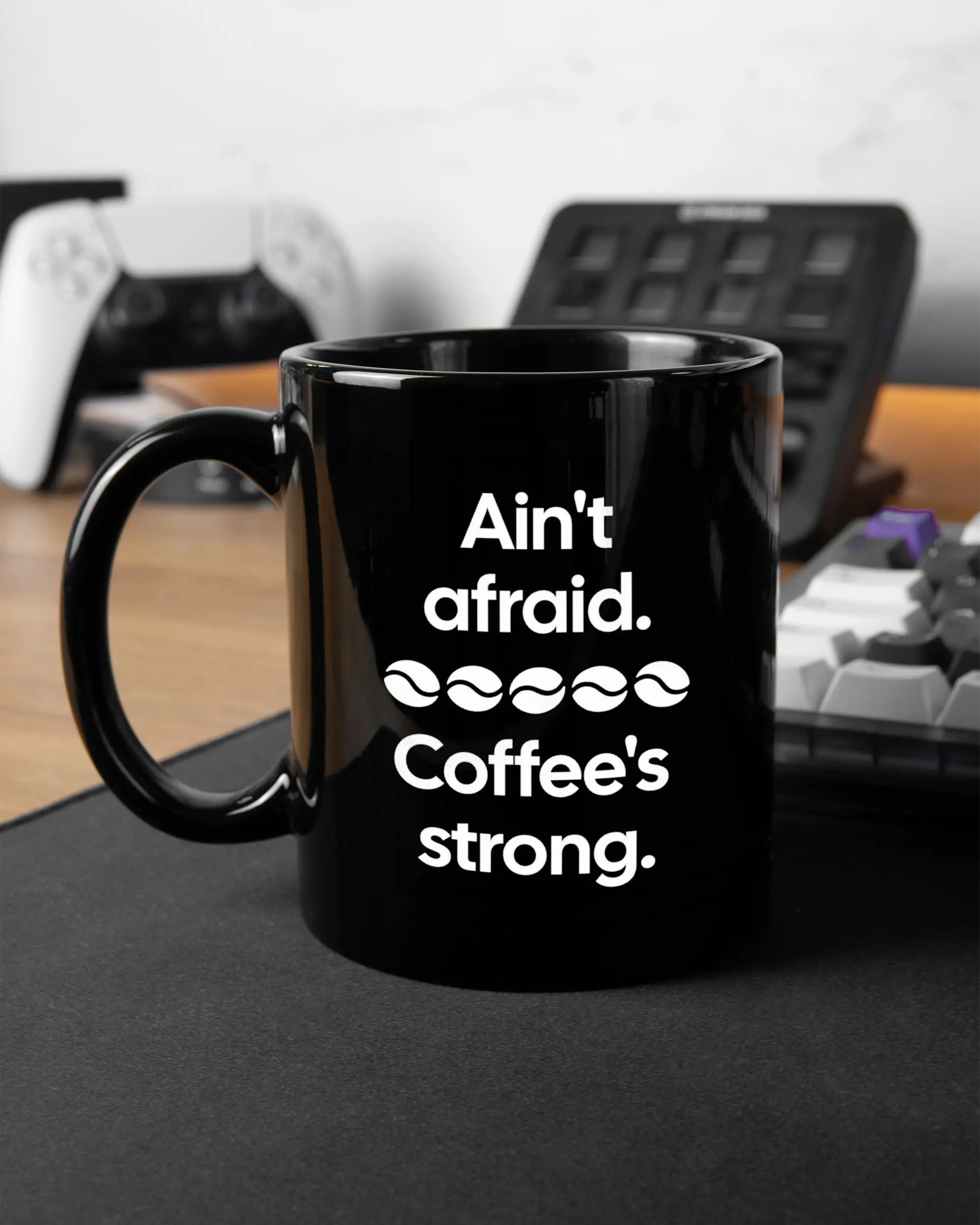 Gaming Room Aufnahme der linken Seite der beidseitig bedruckten Keramiktasse von Maondo mit dem Design Coffee is strong in der Farbe Black