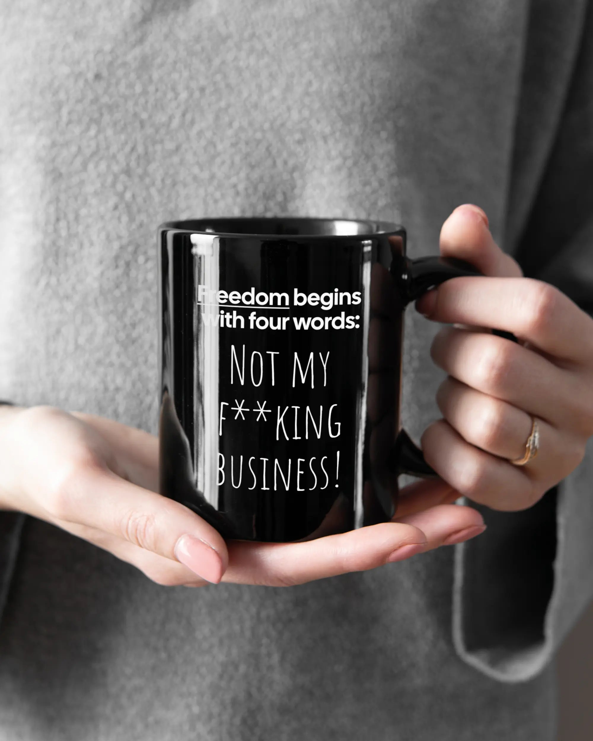 Rechte Seite der beidseitig bedruckten Keramiktasse von Maondo mit dem Design 4 Freedom in der Farbe Black gehalten von Frauenhänden