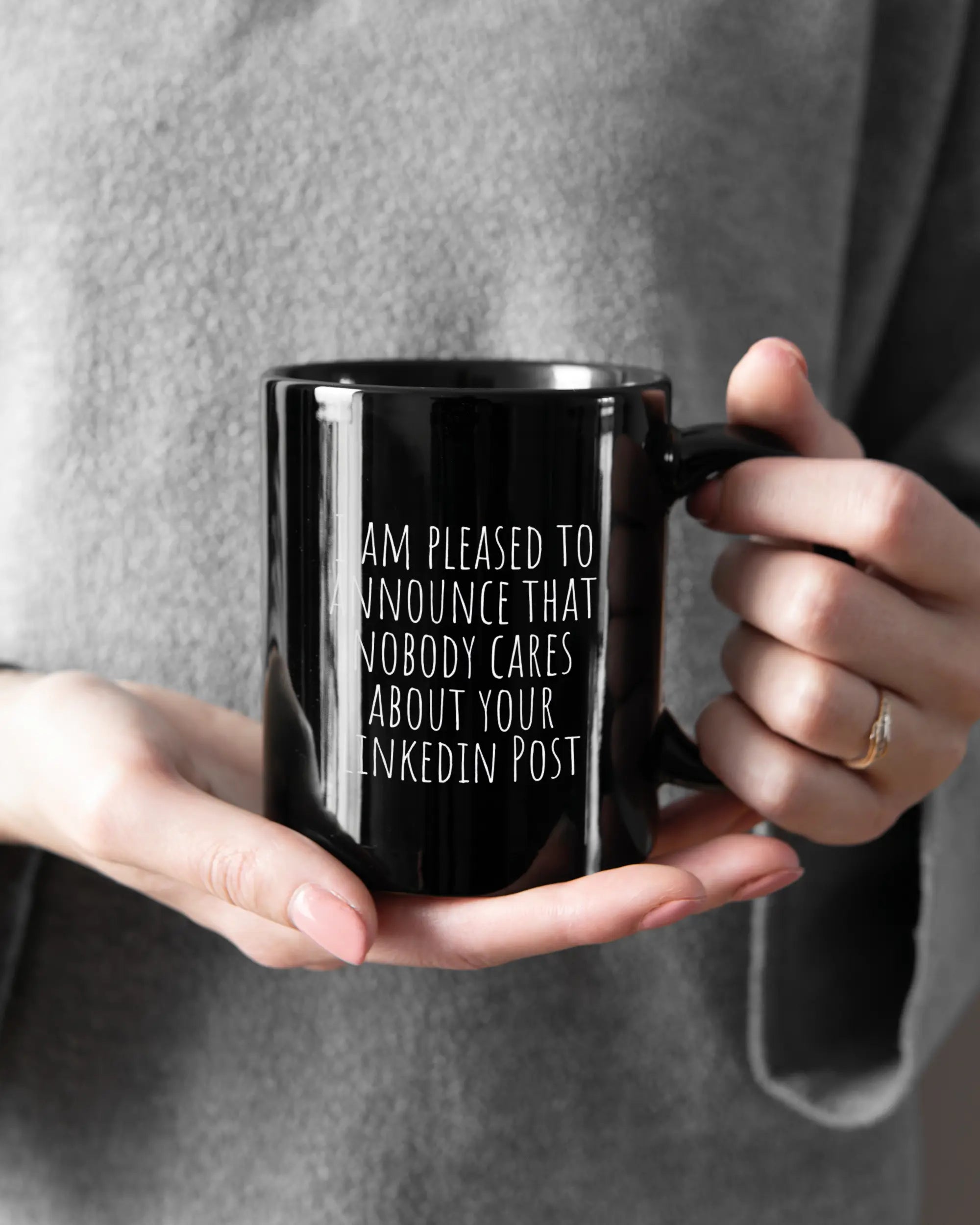 Rechte Seite der beidseitig bedruckten Keramiktasse von Maondo mit dem Design Please Unannounce in der Farbe Black gehalten von Frauenhänden