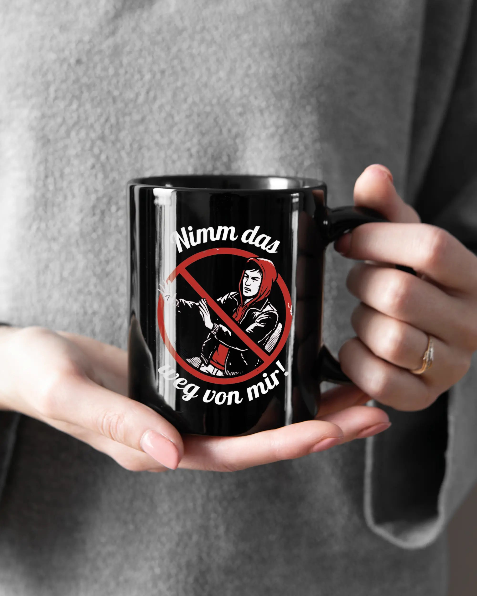 Rechte Seite der beidseitig bedruckten Keramiktasse von Maondo mit dem Design Nimm das weg in der Farbe Black gehalten von Frauenhänden