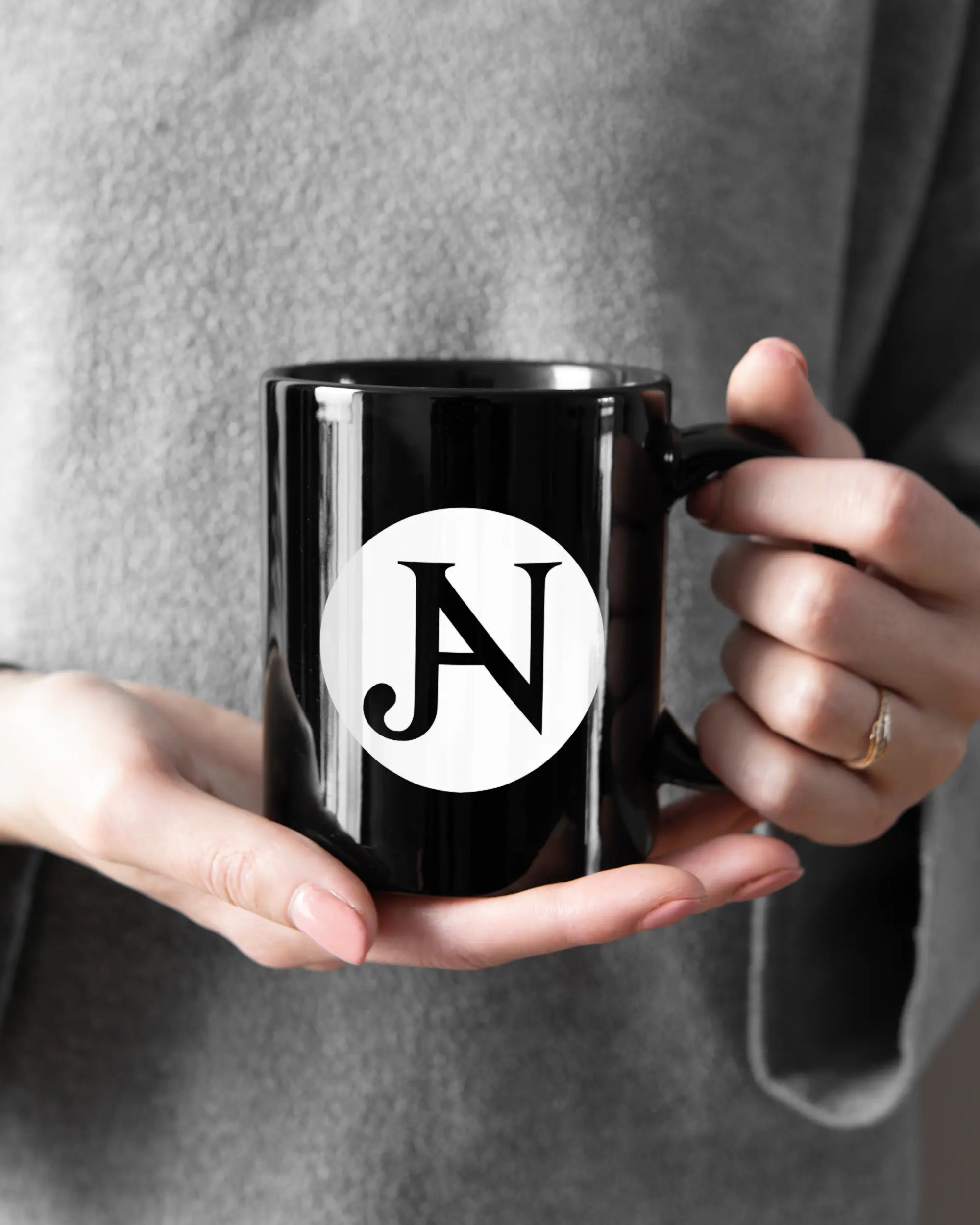 Rechte Seite der beidseitig bedruckten Keramiktasse von Maondo mit dem Design JB1 in der Farbe Black gehalten von Frauenhänden