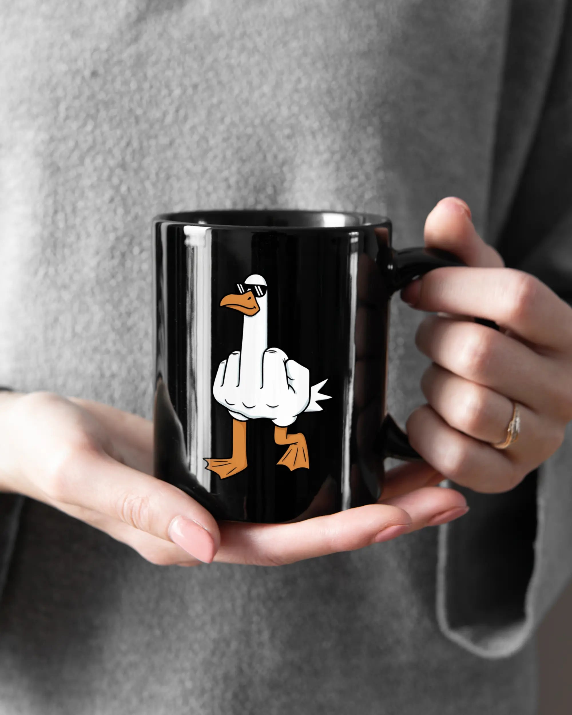 Rechte Seite der beidseitig bedruckten Keramiktasse von Maondo mit dem Design I give a duck in der Farbe Black gehalten von Frauenhänden