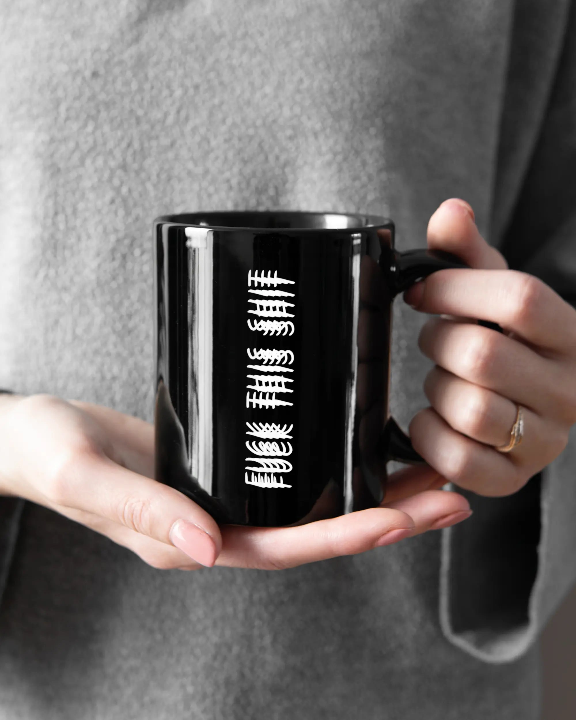 Rechte Seite der beidseitig bedruckten Keramiktasse von Maondo mit dem Design Hidden Message in der Farbe Black gehalten von Frauenhänden