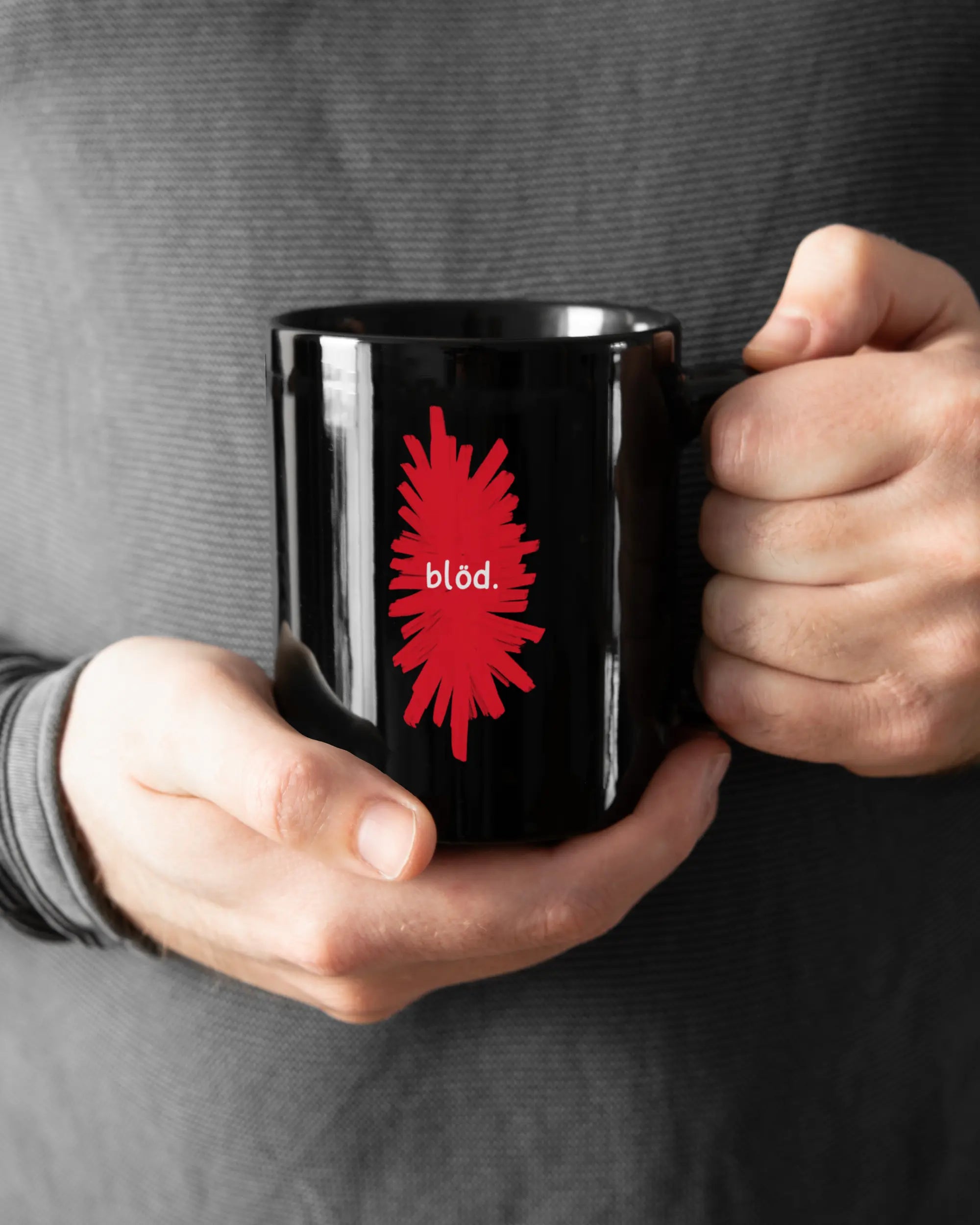 Closeup Modelshot Mann der beidseitig bedruckten Keramik Tasse von Maondo mit dem Design Blöd in der Farbe Schwarz