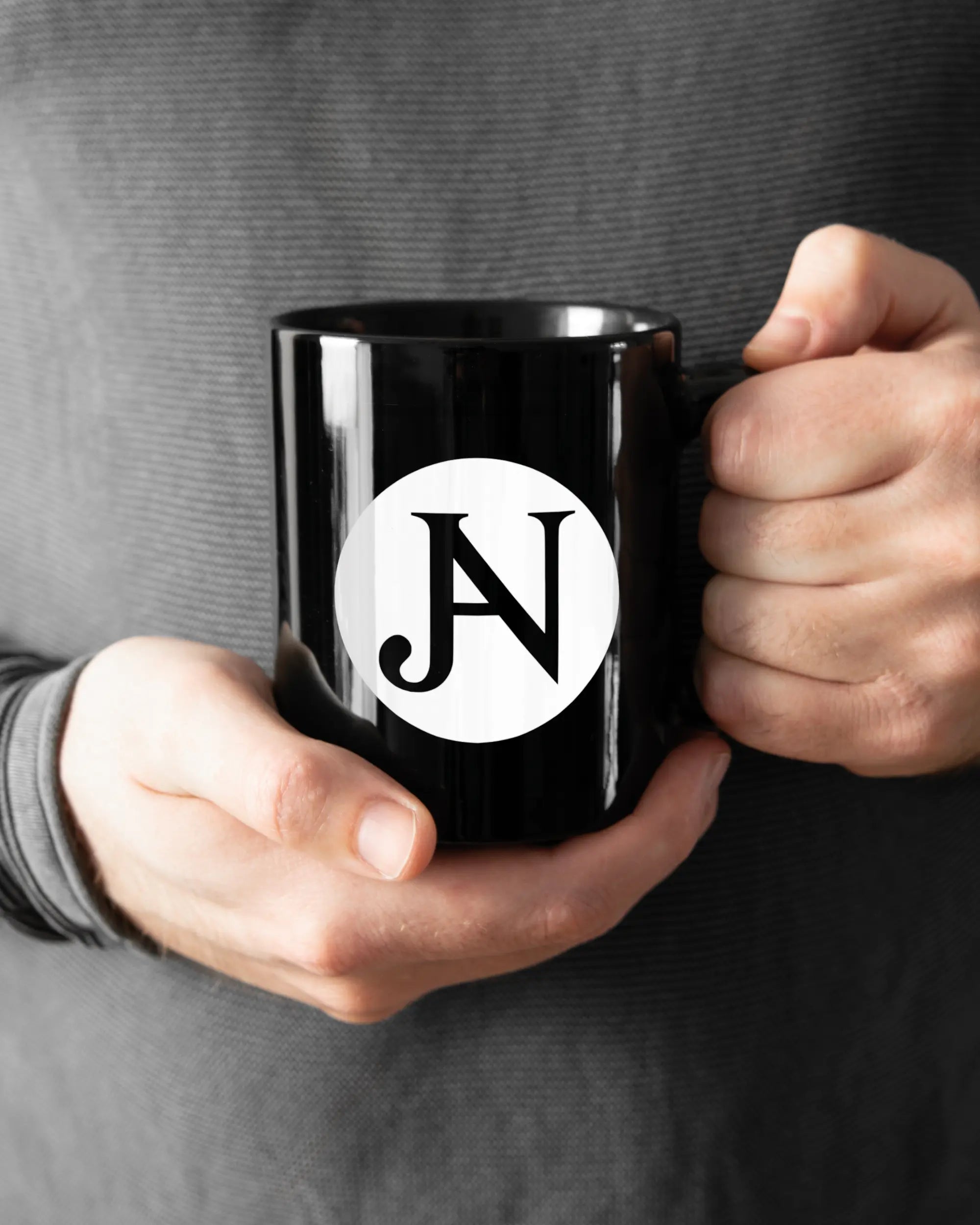 Rechte Seite der beidseitig bedruckten Keramiktasse von Maondo mit dem Design JB1 in der Farbe Black gehalten von Männerhänden