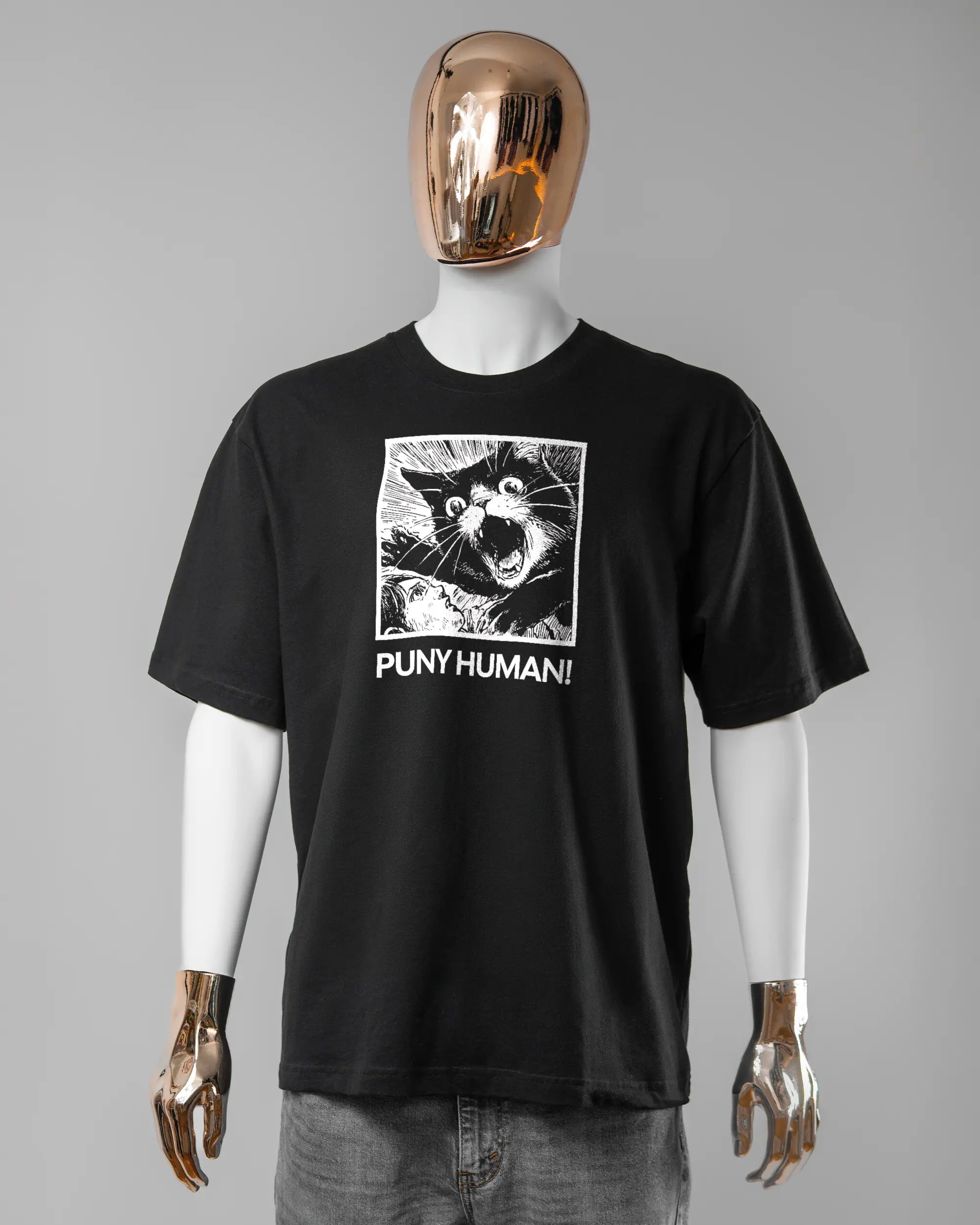 Vorderseite des Basic Unisex T-Shirt Oversized von Maondo mit dem Design Puny Human in der Farbe Black und in der Größe L getragen von einer maskulinen Puppe