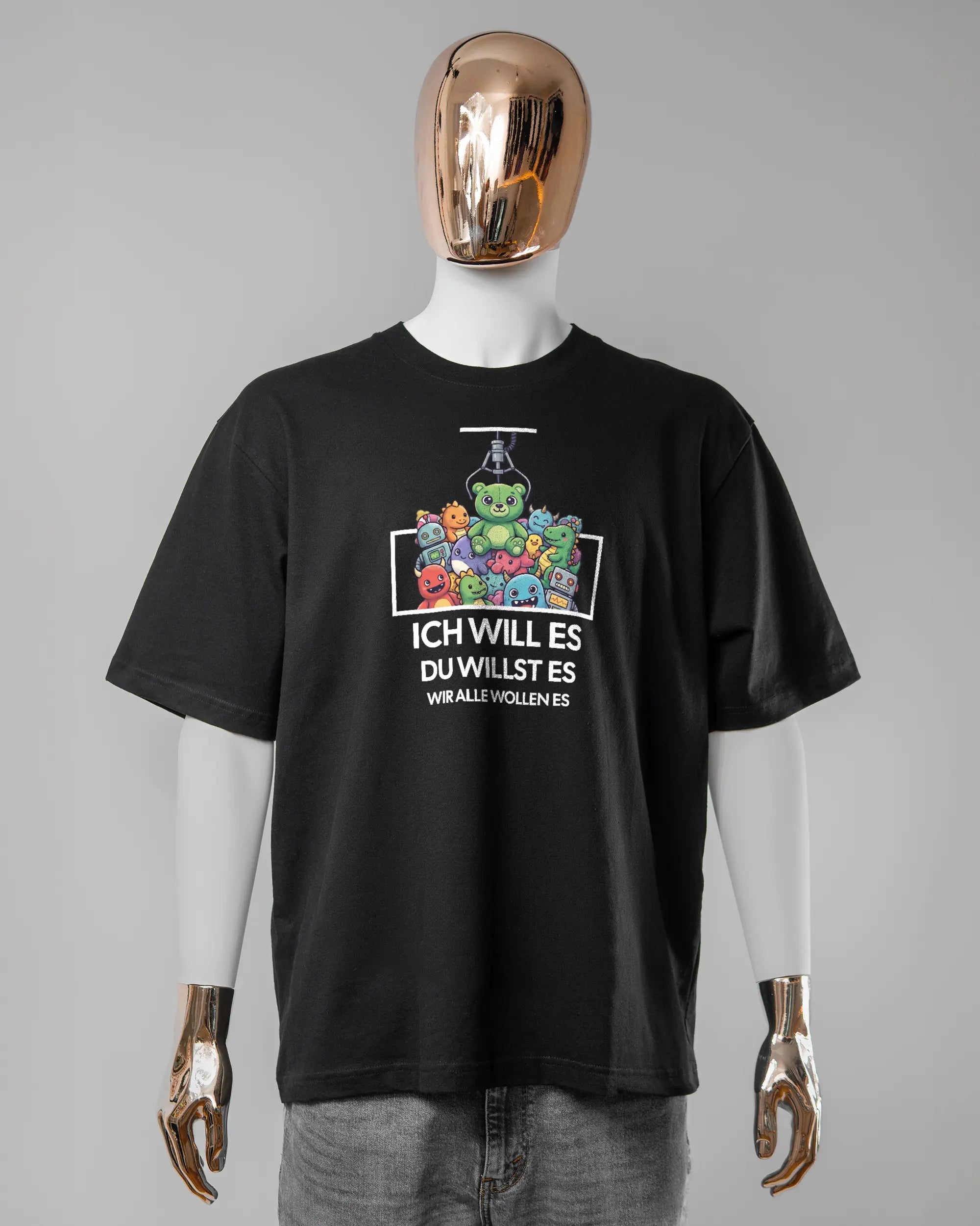 Vorderseite des Basic Unisex T-Shirt Oversized von Maondo mit dem Design Will Stofftier in der Farbe Black und in der Größe L getragen von einer maskulinen Puppe