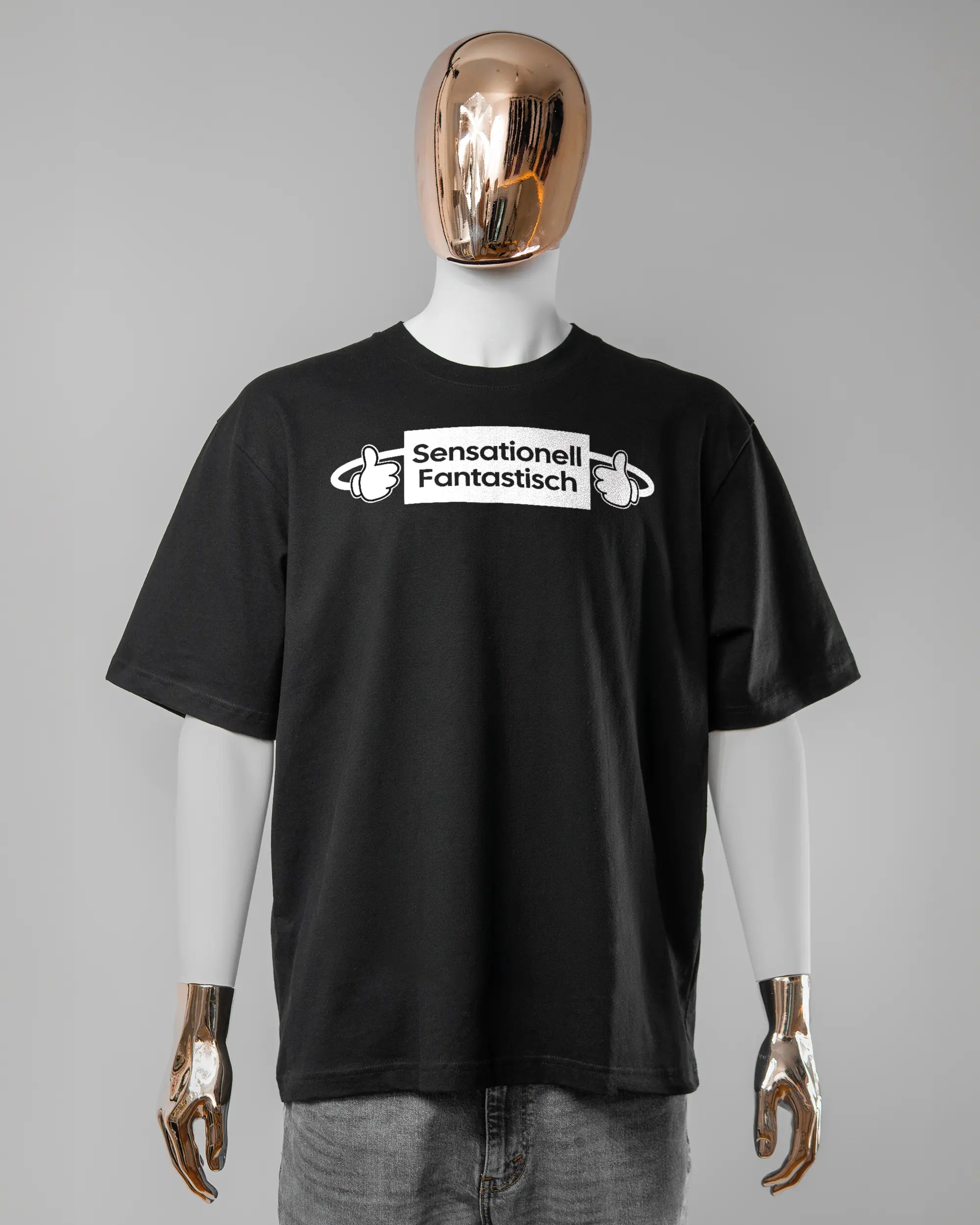 Vorderseite des Basic Unisex T-Shirt Oversized von Maondo mit dem Design Fantastisch in der Farbe Black und in der Größe L getragen von einer maskulinen Puppe