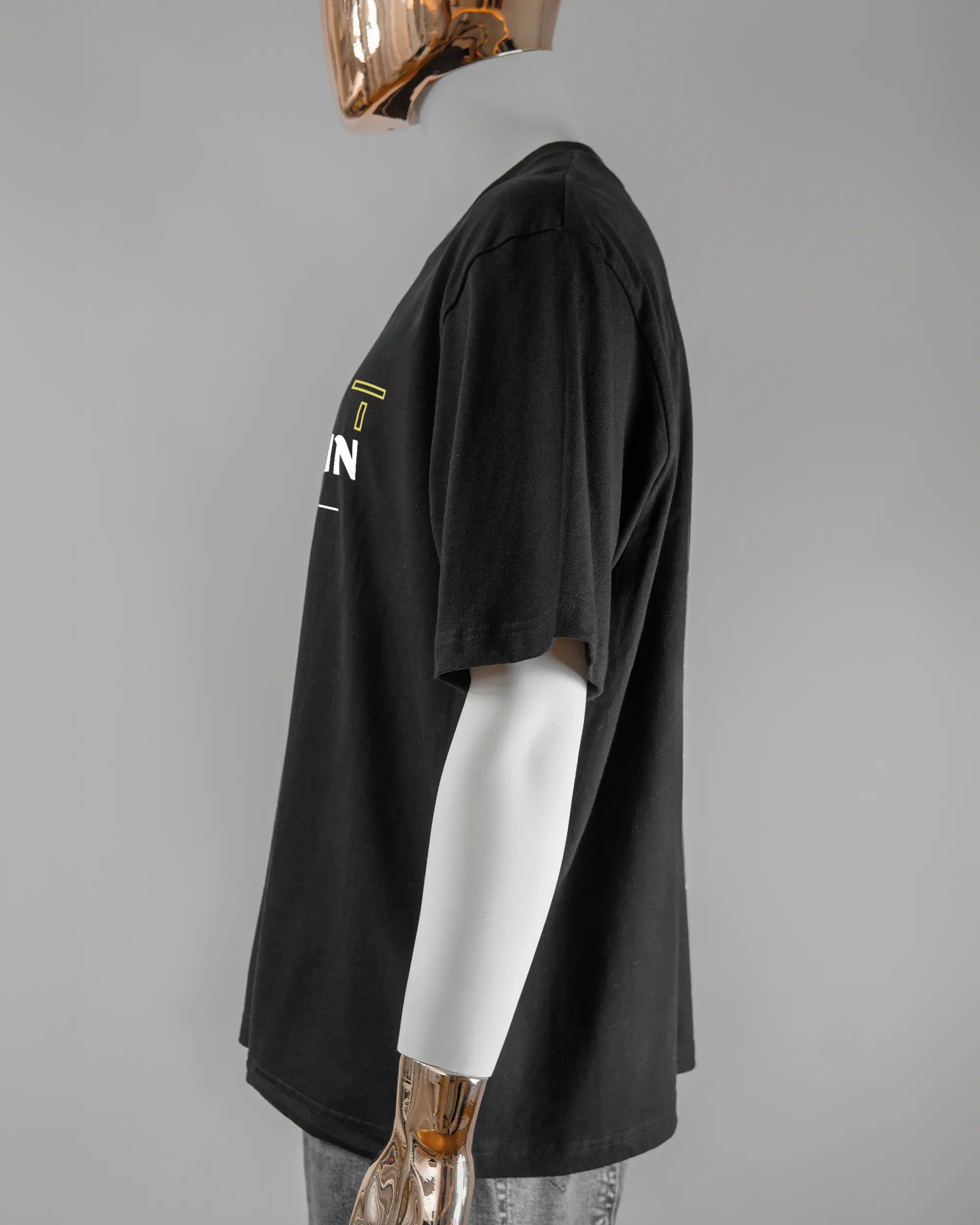 Seitenansicht des Basic Unisex T-Shirt Oversized von Maondo mit dem Design Tracht mit dir vorne in der Farbe Black und in der Größe L getragen von einer maskulinen Puppe