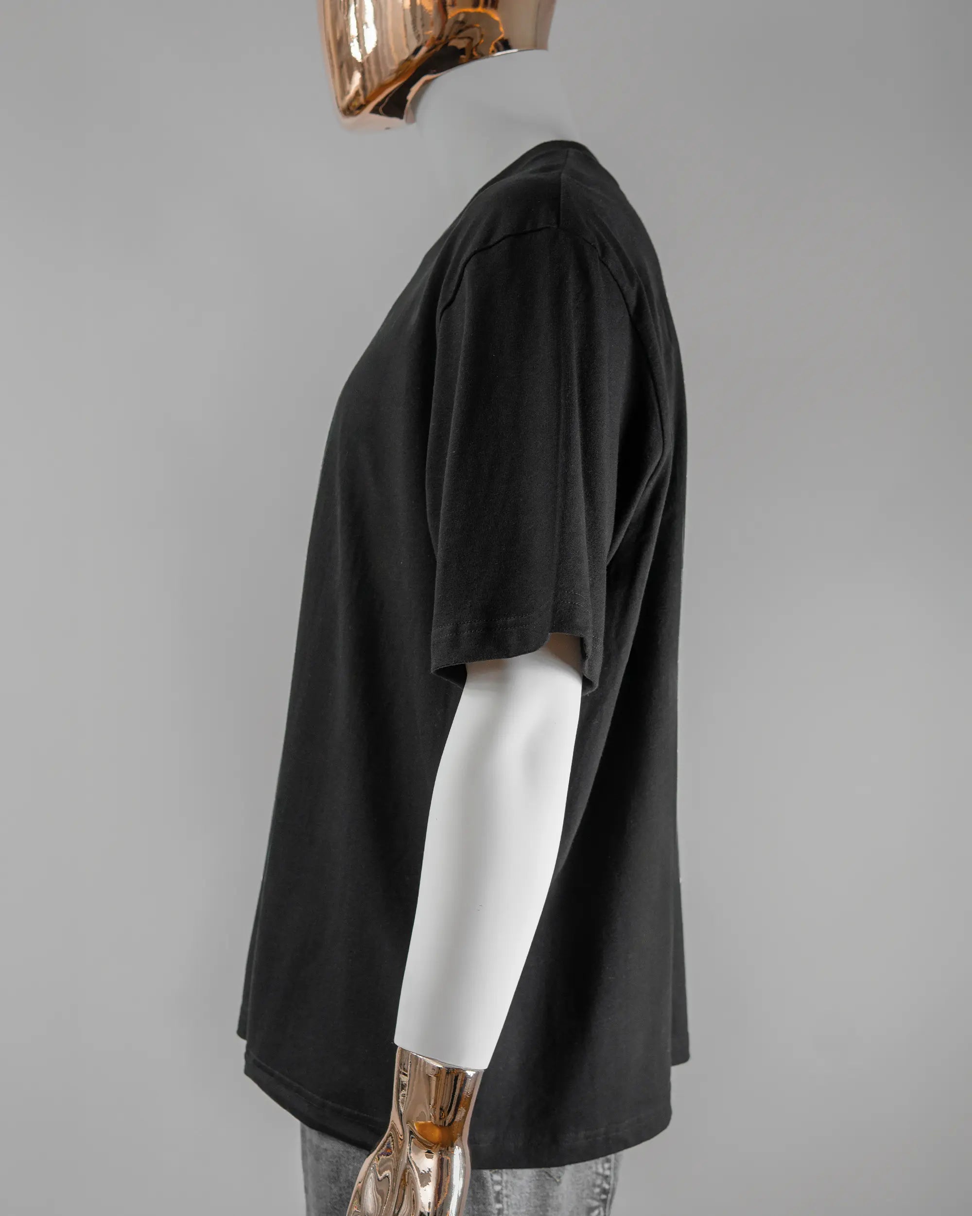 Seitenansicht des Basic Unisex T-Shirt Oversized von Maondo mit dem Design How about nein vorne in der Farbe Black und in der Größe L getragen von einer maskulinen Puppe