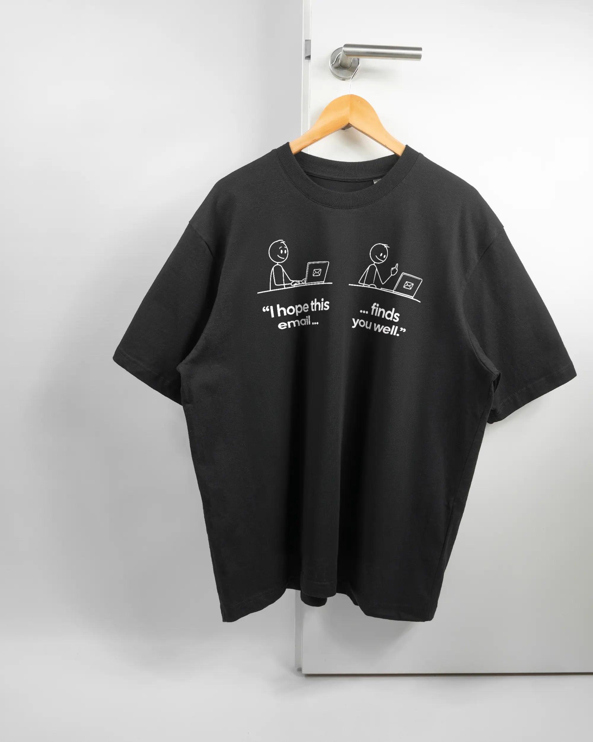 Vorderseite des Basic Unisex T-Shirt Oversized von Maondo mit dem Design Found me not well in der Farbe Black und in der Größe L auf einem Bügel an der Türklinke aufgehängt