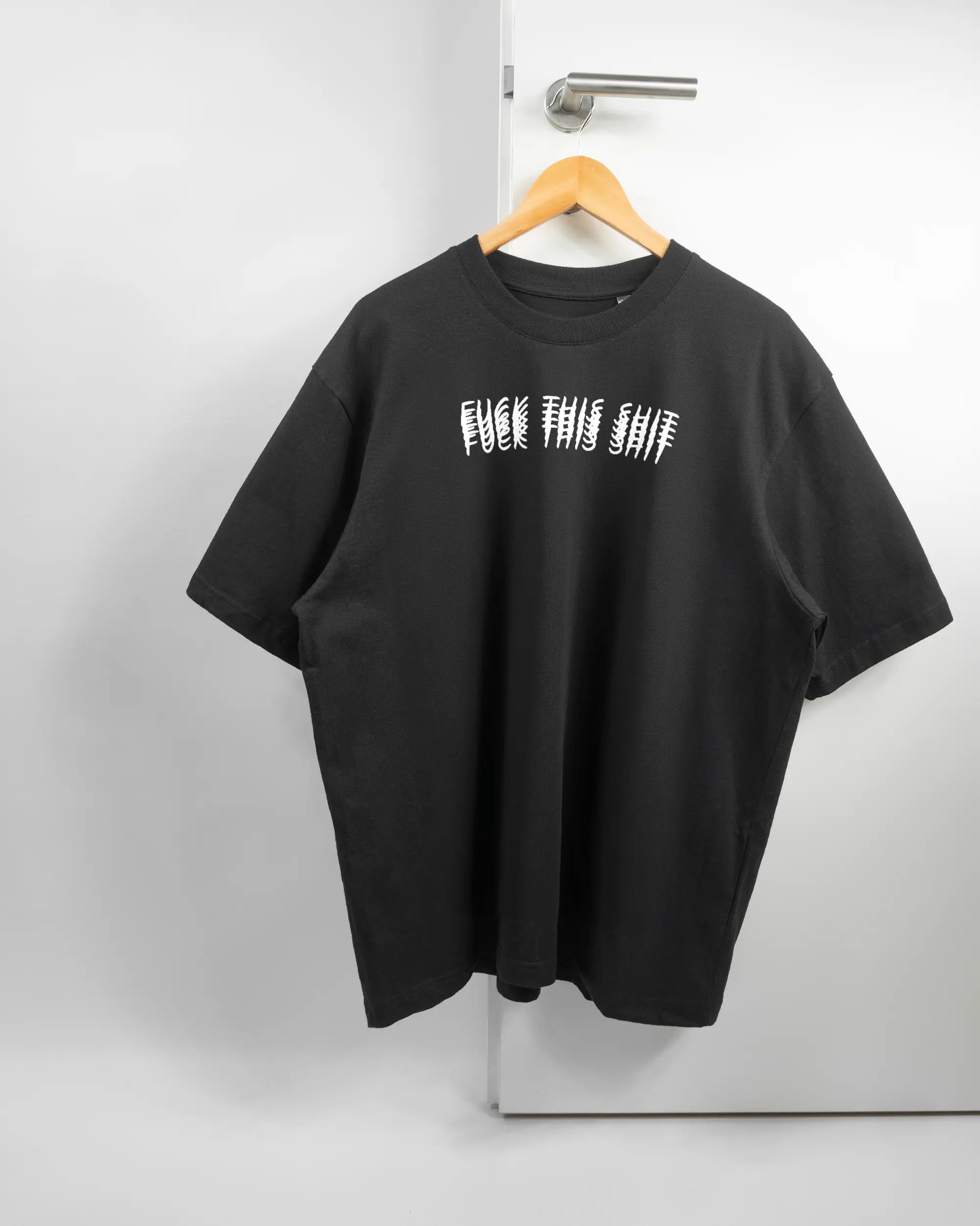 Vorderseite des Basic Unisex T-Shirt Oversized von Maondo mit dem Design Hidden Message in der Farbe Black und in der Größe L auf einem Bügel an der Türklinke aufgehängt