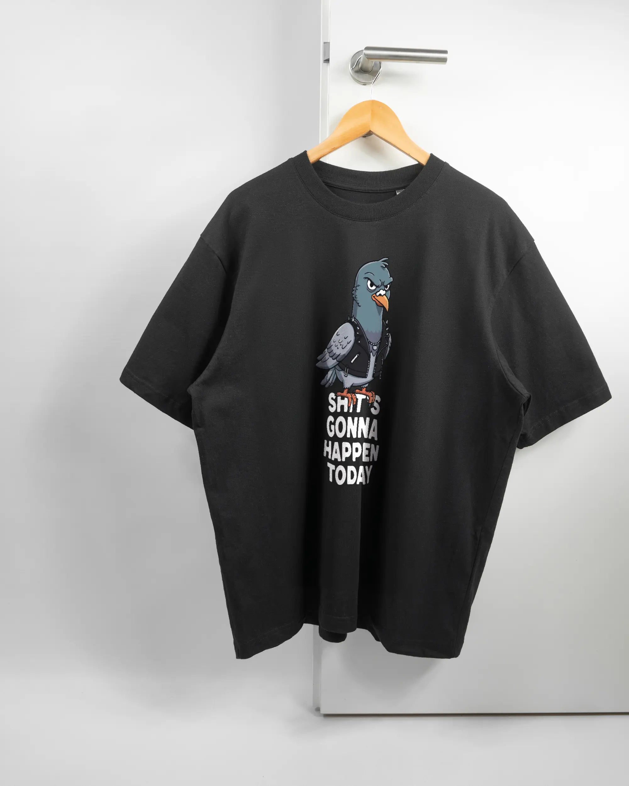 Vorderseite des Basic Unisex T-Shirt Oversized von Maondo mit dem Design Pigeon Pun in der Farbe Black und in der Größe L auf einem Bügel an der Türklinke aufgehängt