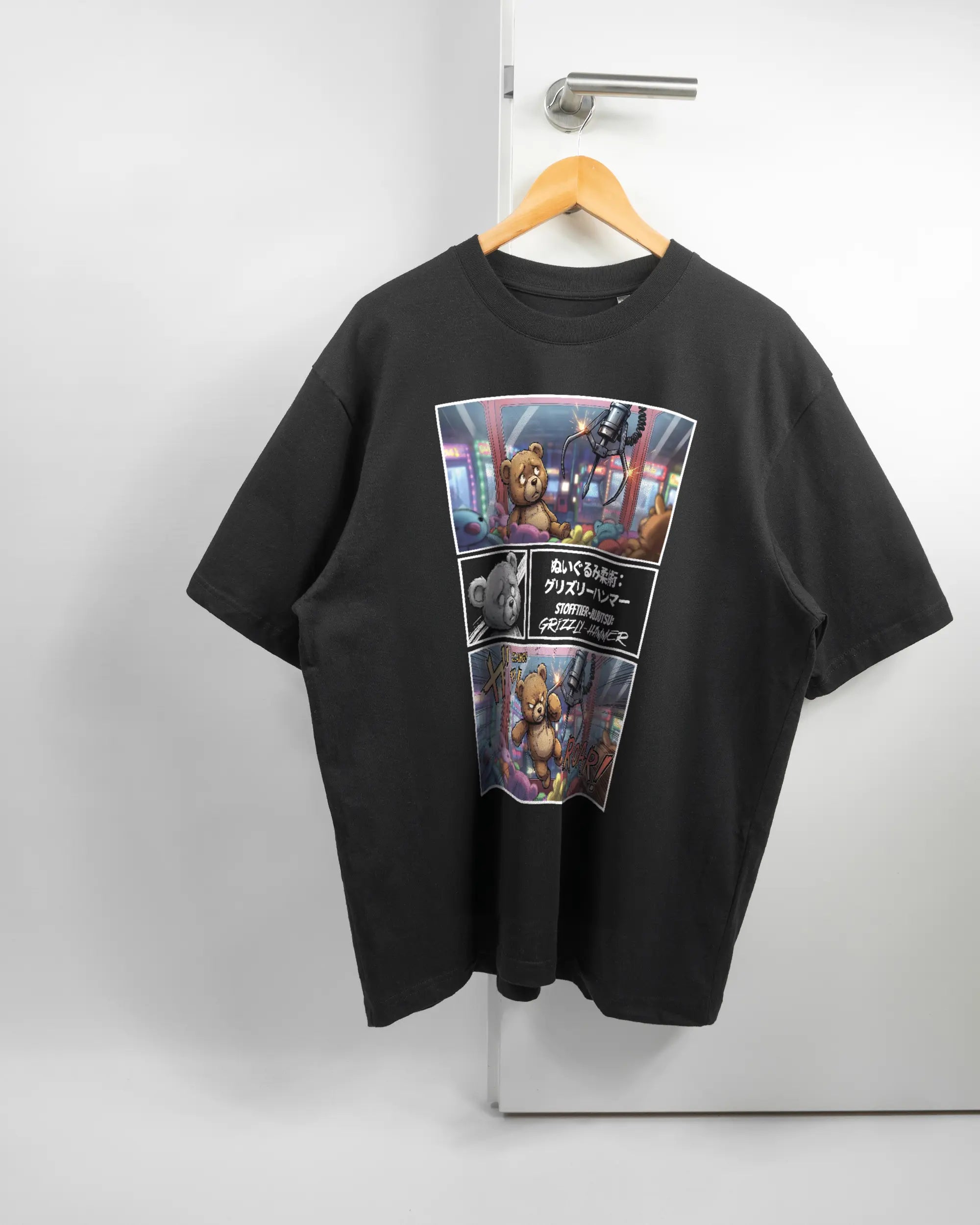Vorderseite des Basic Unisex T-Shirt Oversized von Maondo mit dem Design Manga Stoff in der Farbe Black und in der Größe L auf einem Bügel an der Türklinke aufgehängt