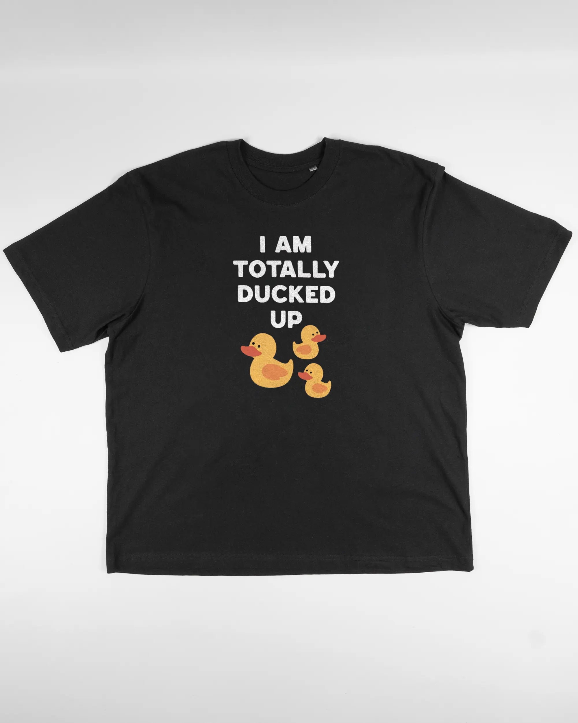 Vorderseite des Basic Unisex T-Shirt Oversized von Maondo mit dem Design Ducked Up in der Farbe Black und in der Größe L flach auf den Boden gelegt