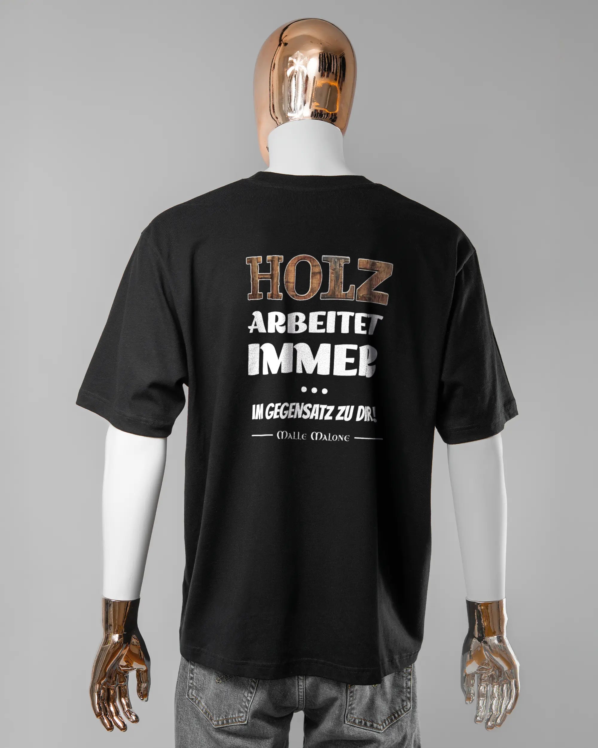 Rückseite des Basic Unisex T-Shirt Oversized von Maondo mit dem Design Holzarbeit in der Farbe Black und in der Größe L getragen von einer maskulinen Puppe