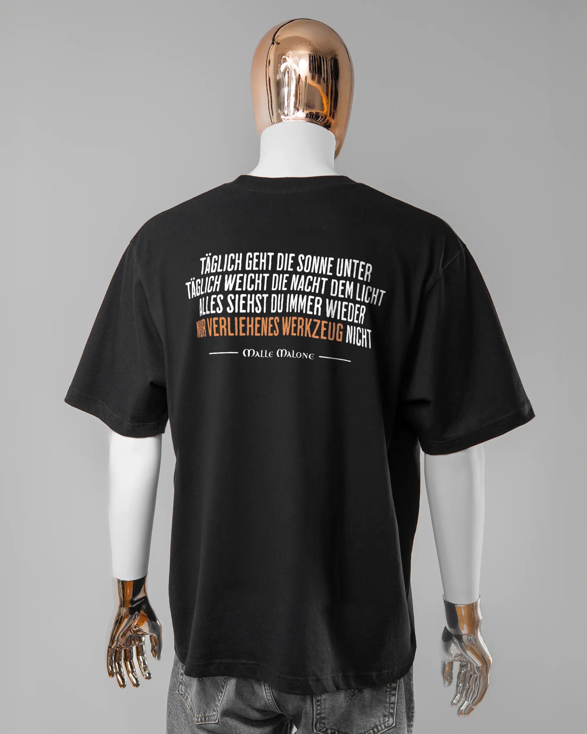 Rückseite des Basic Unisex T-Shirt Oversized von Maondo mit dem Design Wegzeug in der Farbe Black und in der Größe L getragen von einer maskulinen Puppe