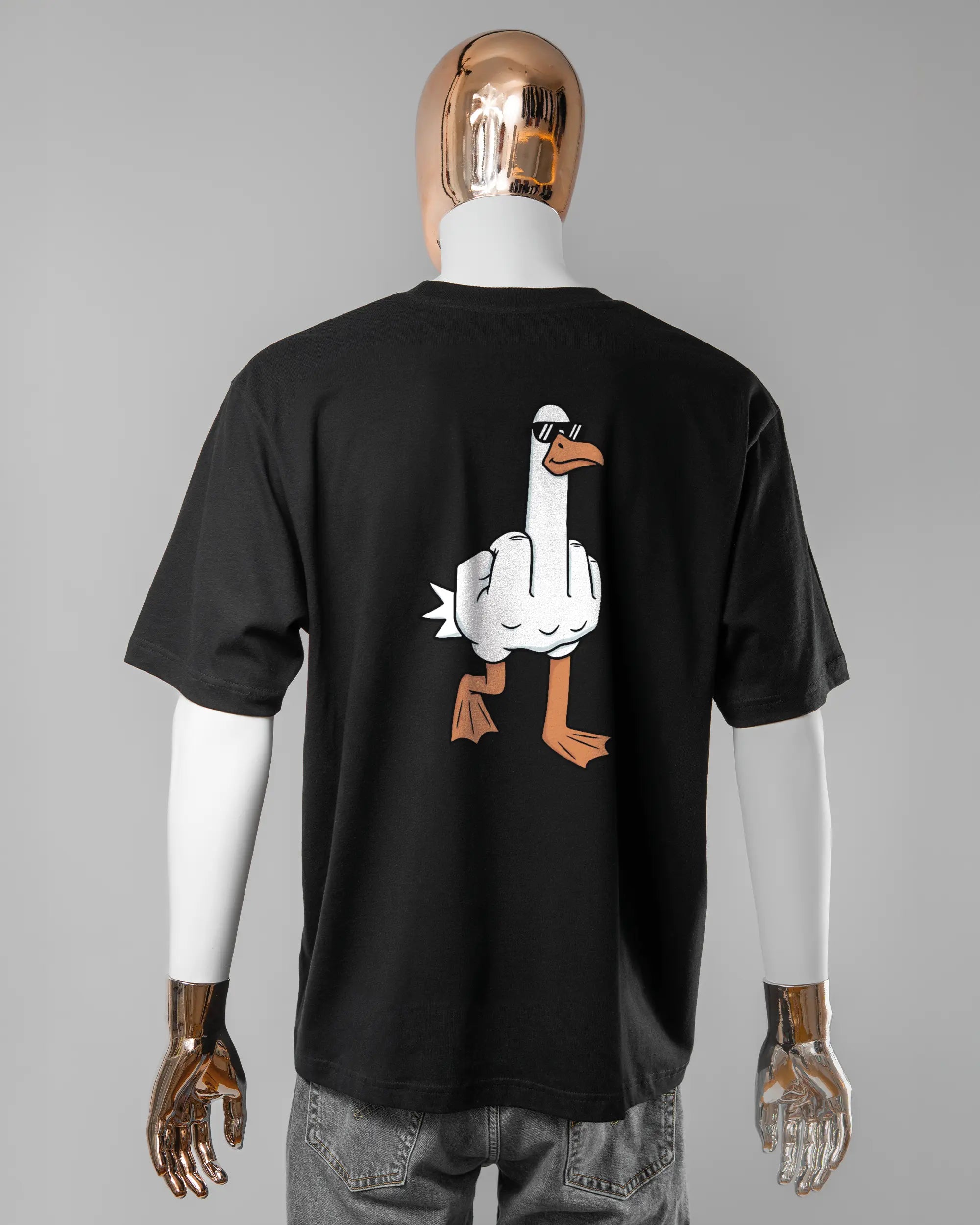 Rückseite des Basic Unisex T-Shirt Oversized von Maondo mit dem Design I give a duck in der Farbe Black und in der Größe L getragen von einer maskulinen Puppe