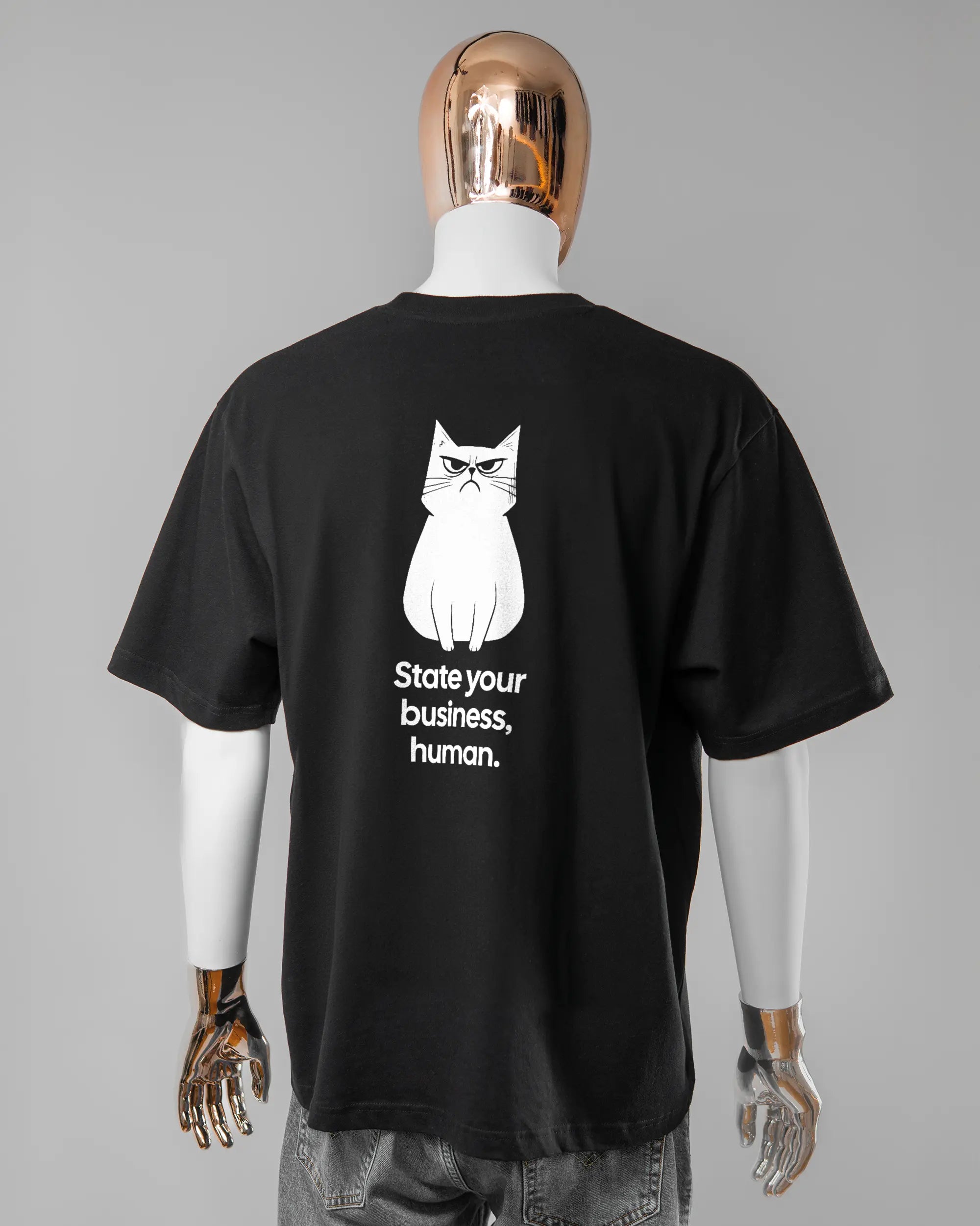 Rückseite des Basic Unisex T-Shirt Oversized von Maondo mit dem Design Grumpy Purr in der Farbe Black und in der Größe L getragen von einer maskulinen Puppe