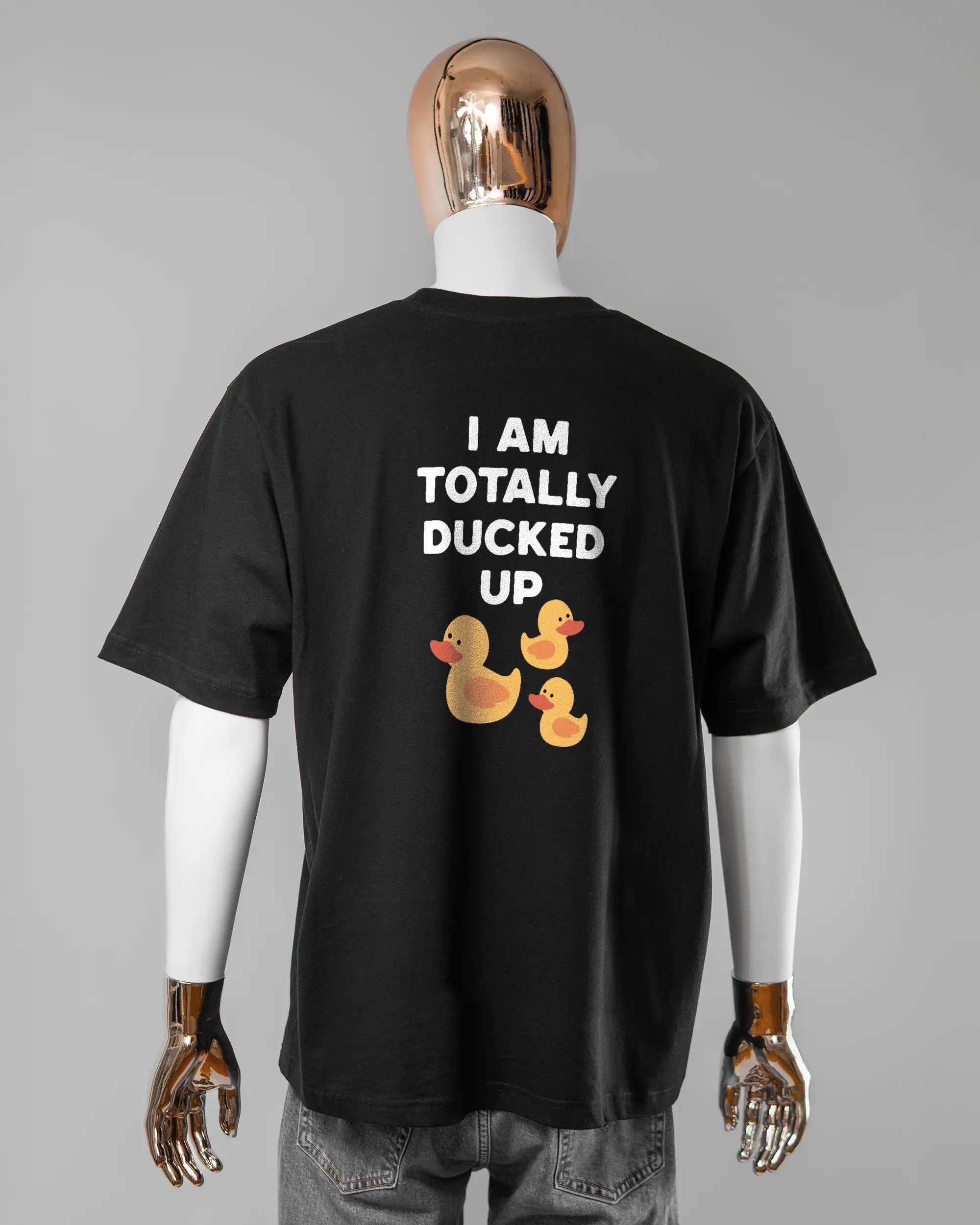 Rückseite des Basic Unisex T-Shirt Oversized von Maondo mit dem Design Ducked Up in der Farbe Black und in der Größe L getragen von einer maskulinen Puppe