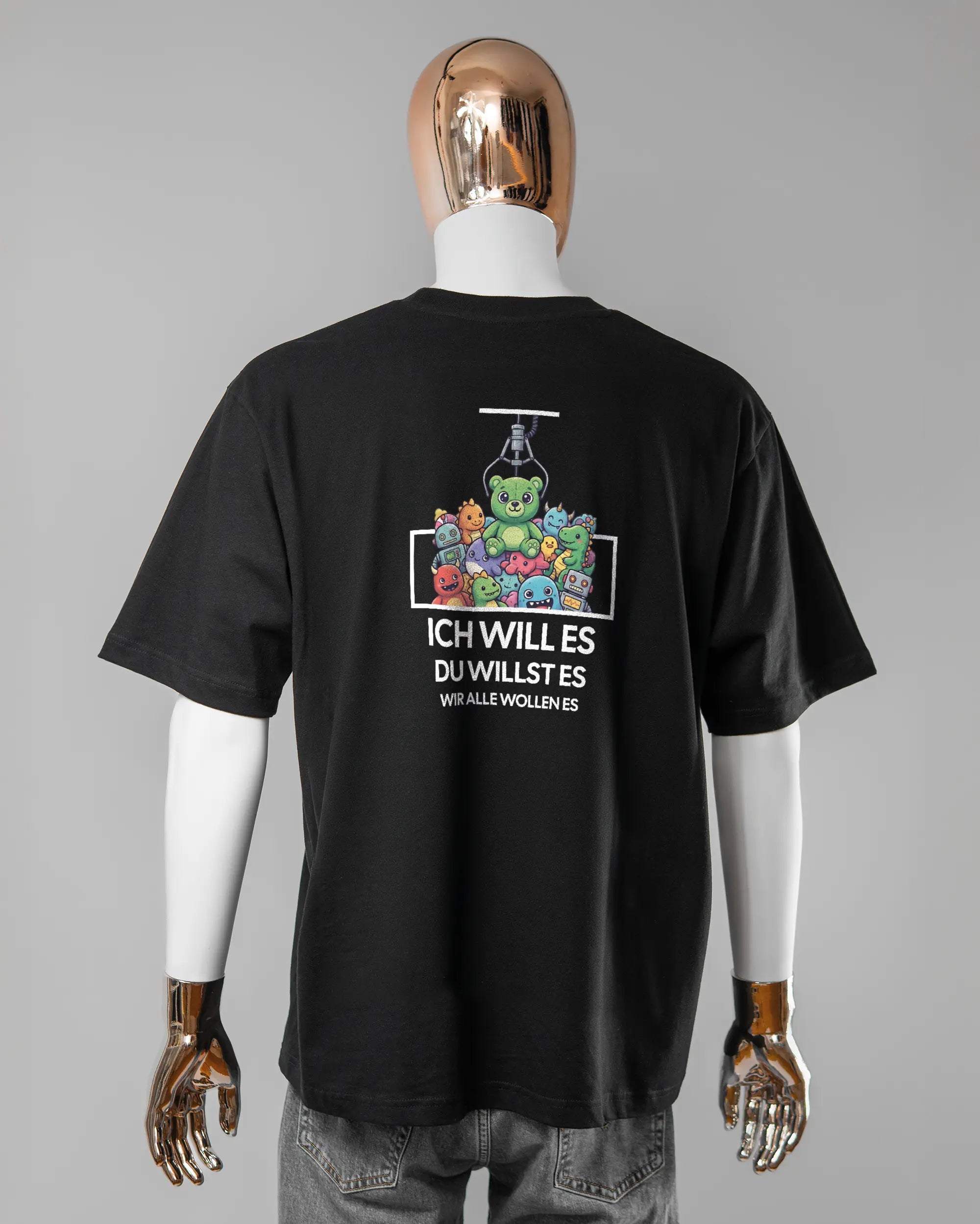 Rückseite des Basic Unisex T-Shirt Oversized von Maondo mit dem Design Will Stofftier in der Farbe Black und in der Größe L getragen von einer maskulinen Puppe