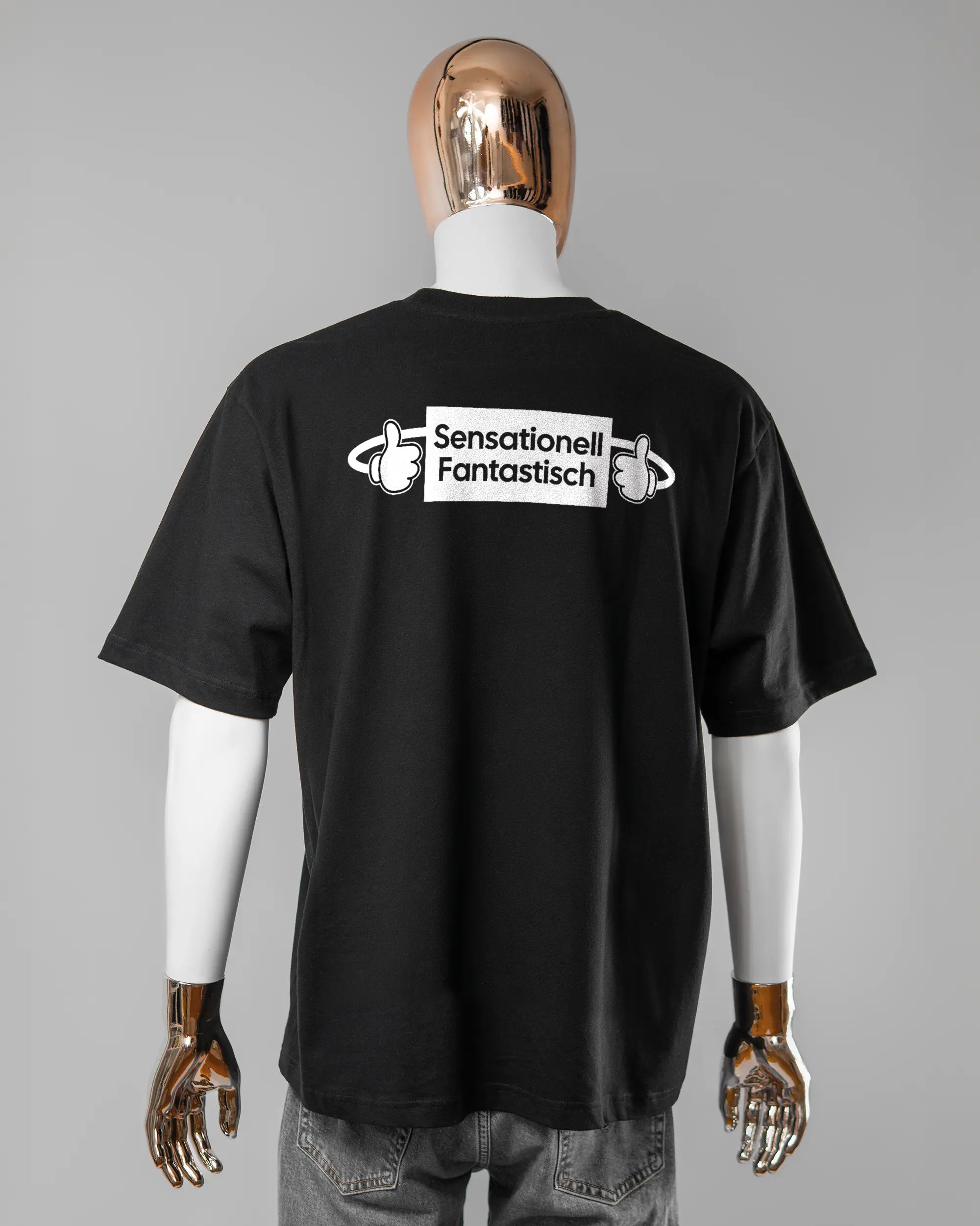 Rückseite des Basic Unisex T-Shirt Oversized von Maondo mit dem Design Fantastisch in der Farbe Black und in der Größe L getragen von einer maskulinen Puppe