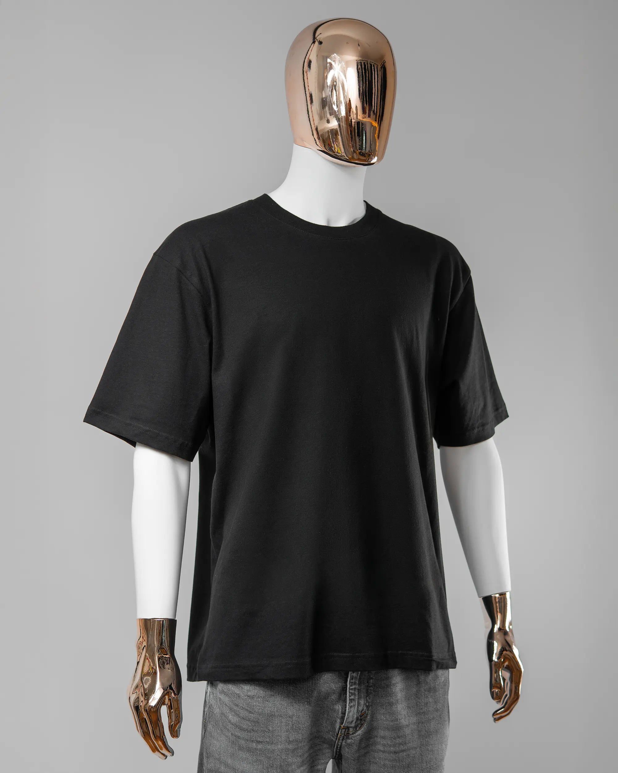 Vorderseite des Basic Unisex T-Shirt Oversized von Maondo ohne Motiv in der Farbe Black und in der Größe L getragen von einer maskulinen Puppe