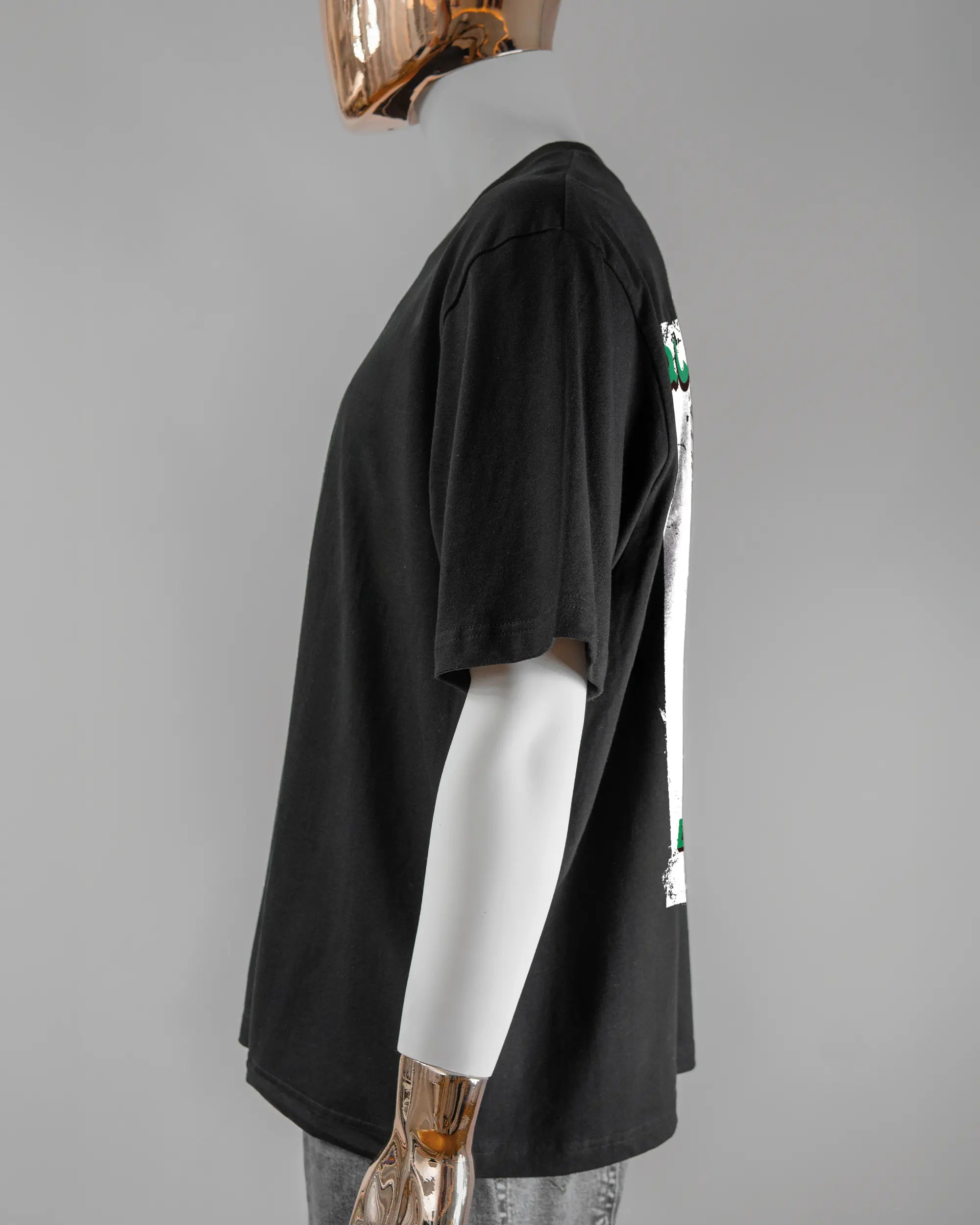 Seitenansicht des Basic Unisex T-Shirt Oversized von Maondo mit dem Design Save 1 Stofftier hinten in der Farbe Black und in der Größe L getragen von einer maskulinen Puppe