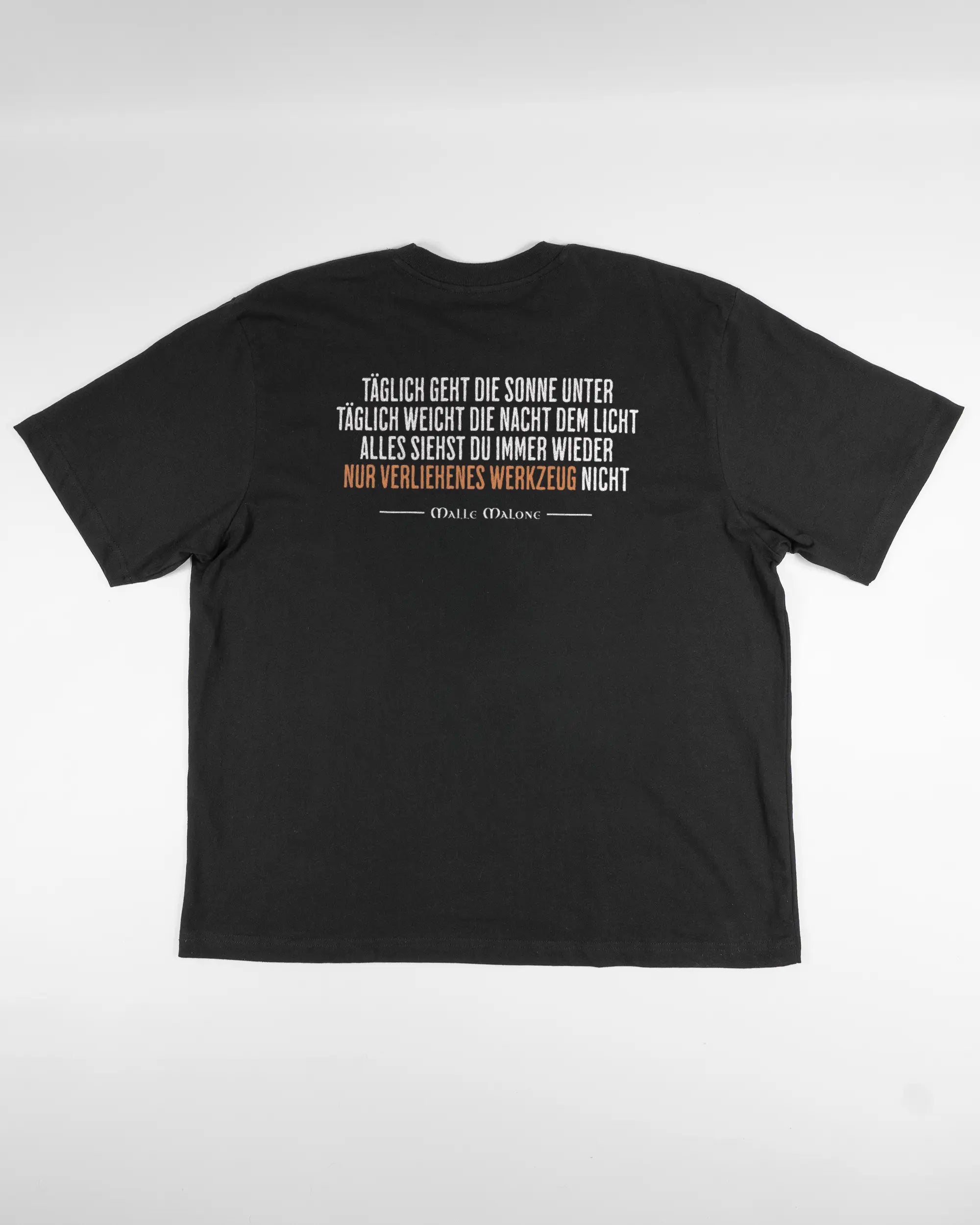 Rückseite des Basic Unisex T-Shirt Oversized von Maondo mit dem Design Wegzeug in der Farbe Black und in der Größe L flach auf den Boden gelegt