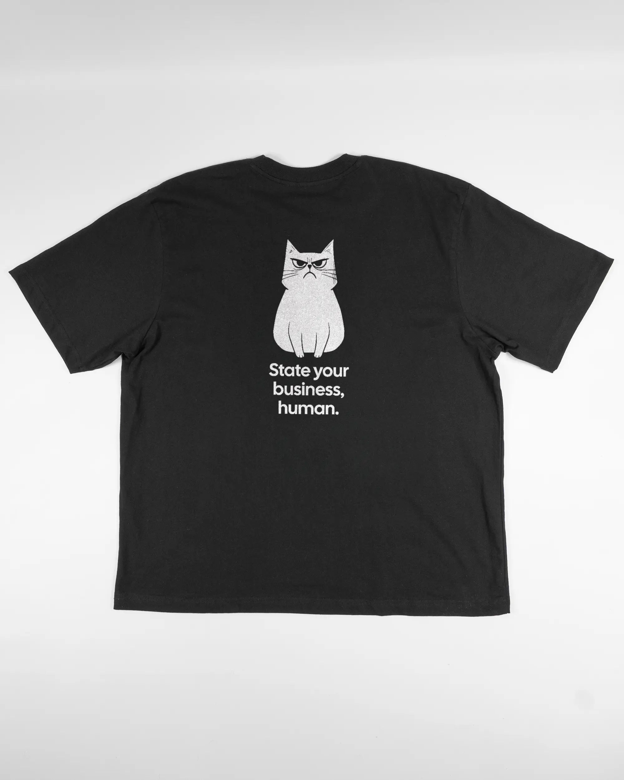 Rückseite des Basic Unisex T-Shirt Oversized von Maondo mit dem Design Grumpy Purr in der Farbe Black und in der Größe L flach auf den Boden gelegt