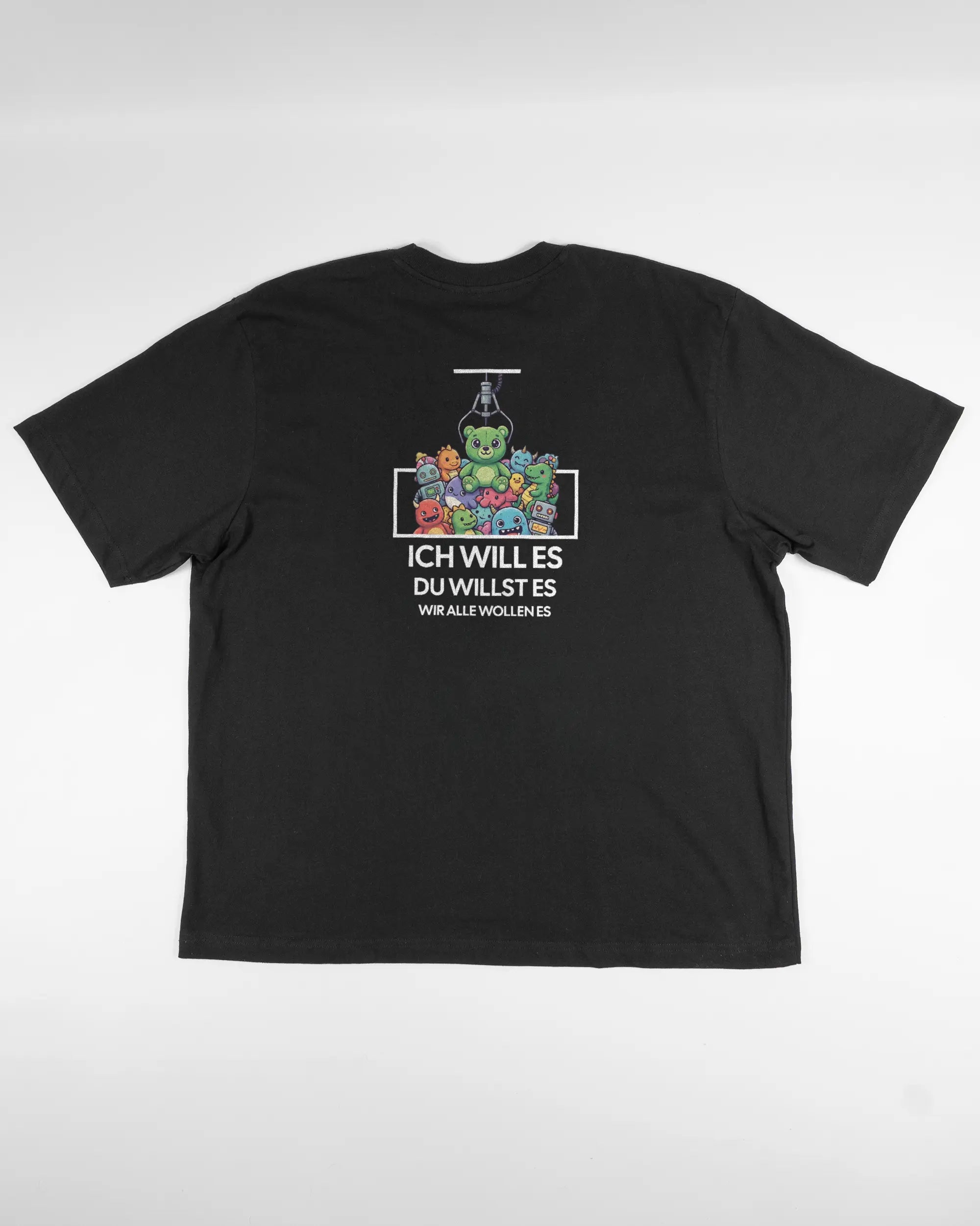 Rückseite des Basic Unisex T-Shirt Oversized von Maondo mit dem Design Will Stofftier in der Farbe Black und in der Größe L flach auf den Boden gelegt