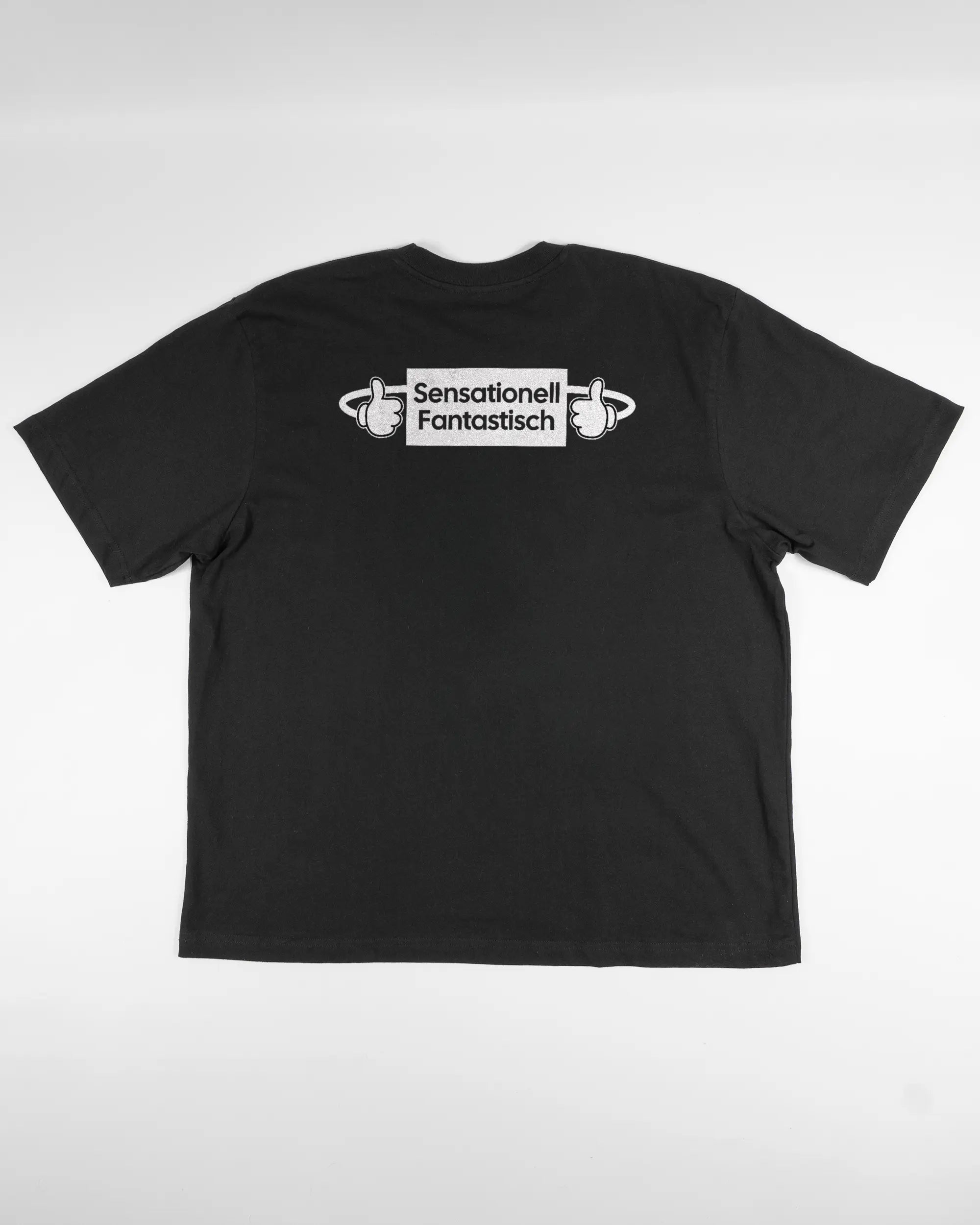 Rückseite des Basic Unisex T-Shirt Oversized von Maondo mit dem Design Fantastisch in der Farbe Black und in der Größe L flach auf den Boden gelegt