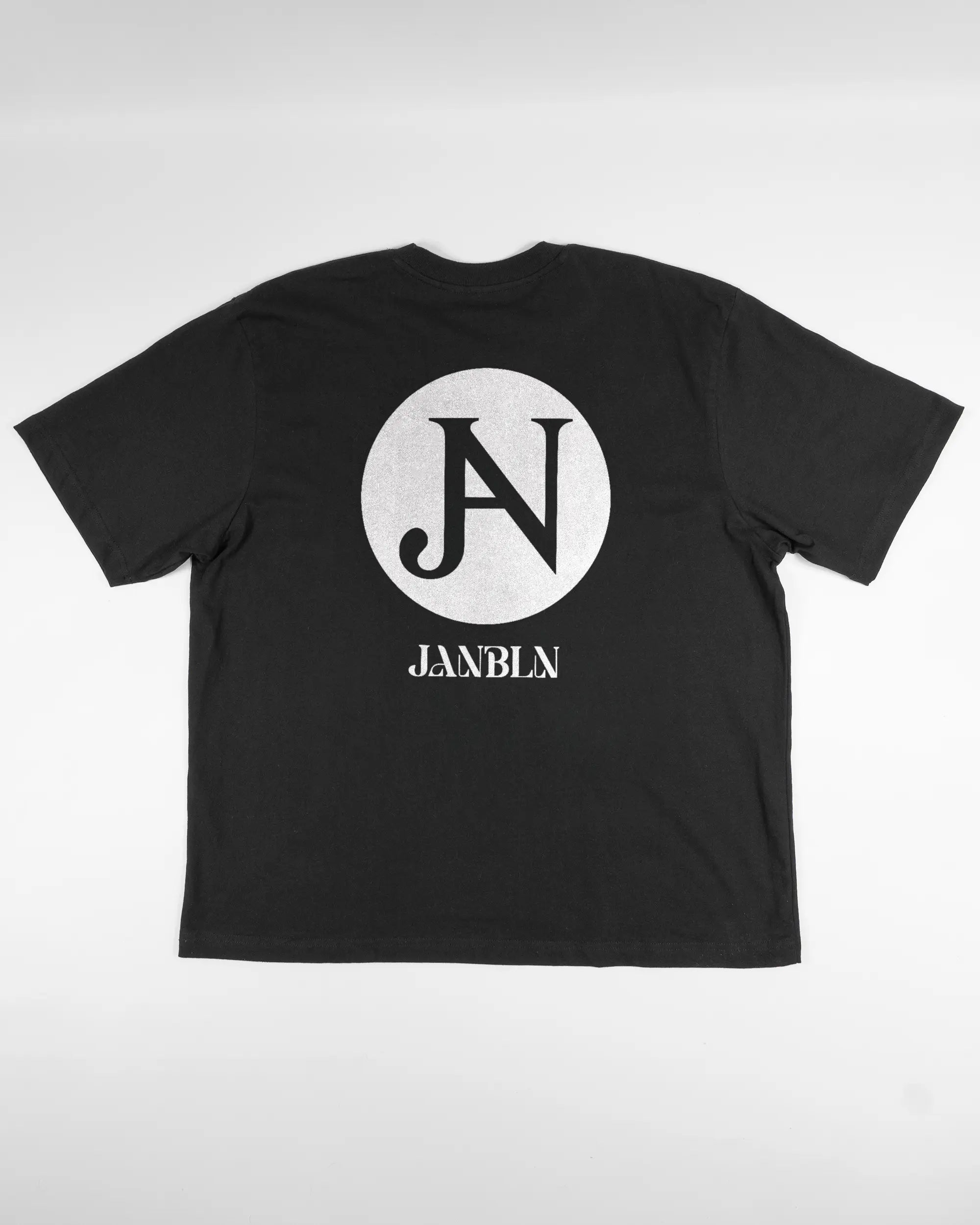Rückseite des Basic Unisex T-Shirt Oversized von Maondo mit dem Design JB1 in der Farbe Black und in der Größe L flach auf den Boden gelegt