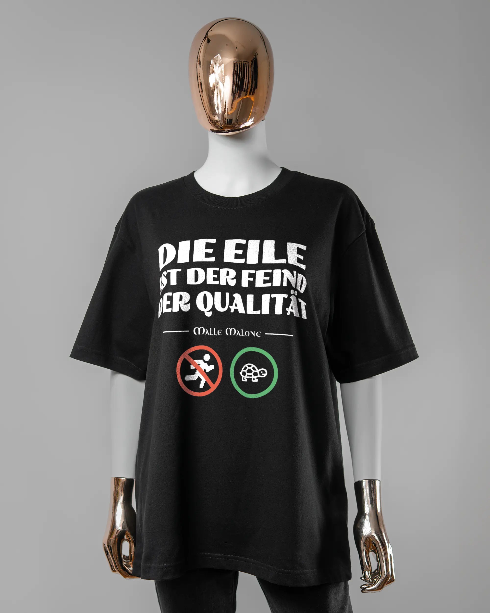 Vorderseite des Basic Unisex T-Shirt Oversized von Maondo mit dem Design Keine Eile in der Farbe Black und in der Größe S getragen von einer femininen Puppe