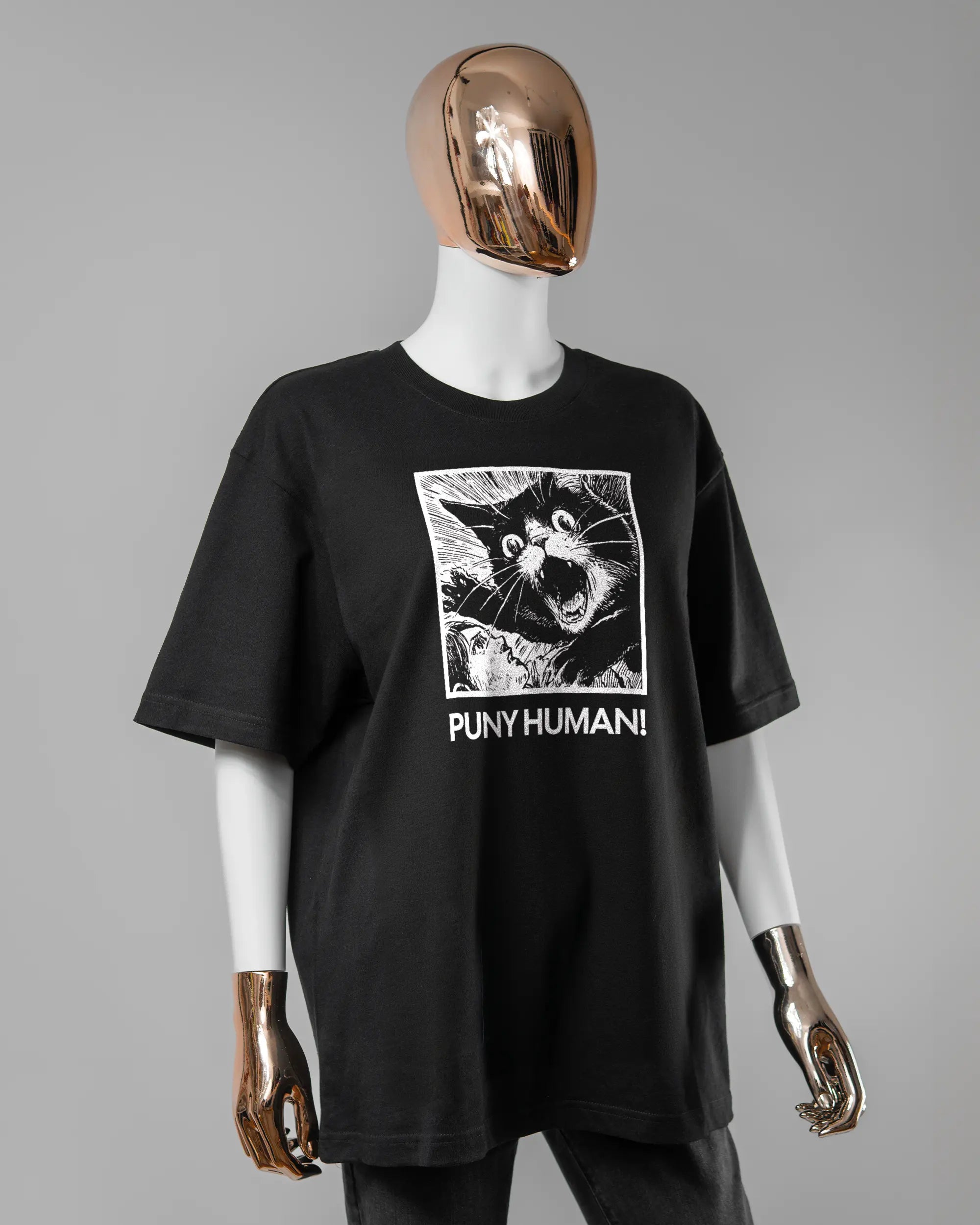 Vorderseite des Basic Unisex T-Shirt Oversized von Maondo mit dem Design Puny Human in der Farbe Black und in der Größe S getragen von einer femininen Puppe