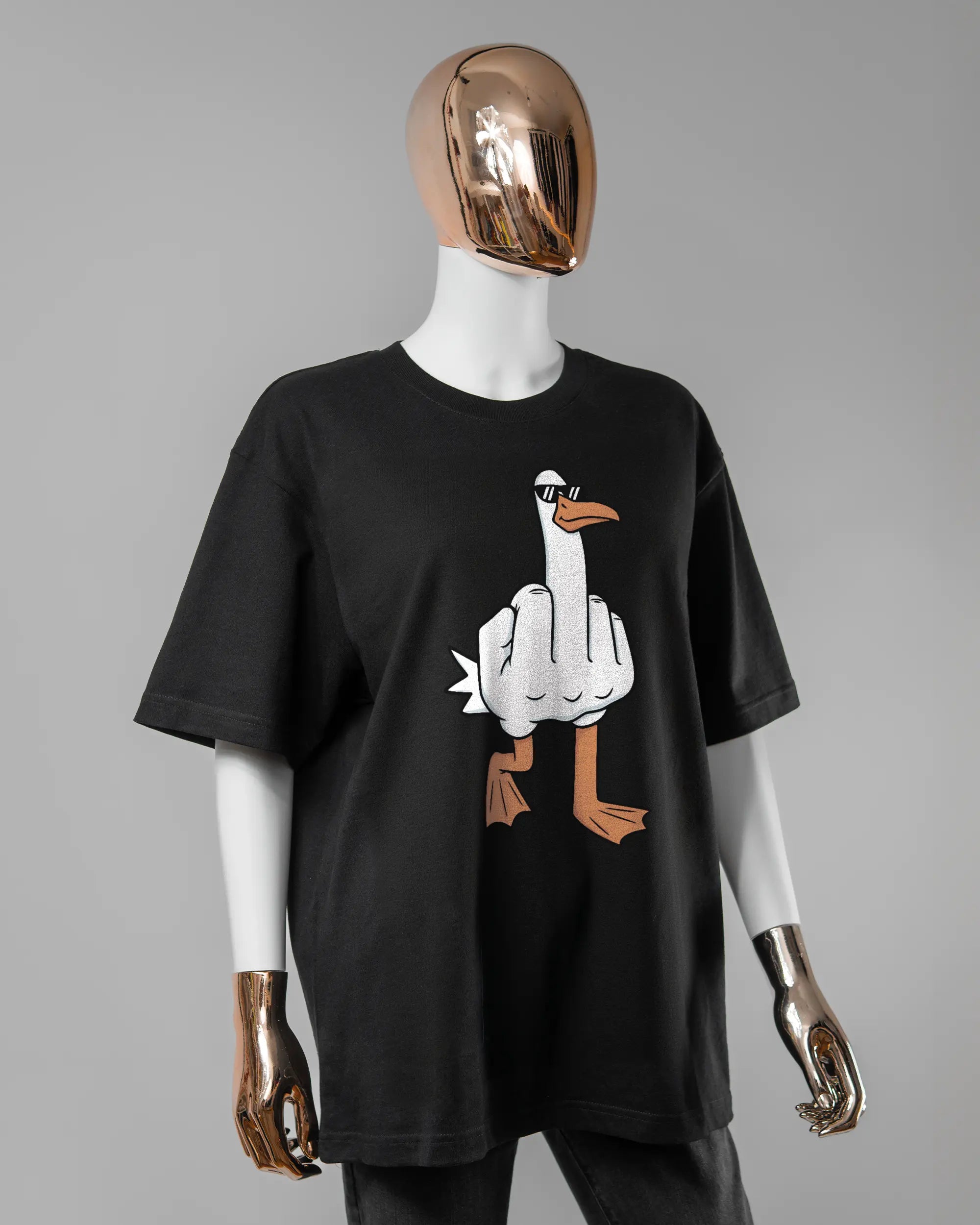 Vorderseite des Basic Unisex T-Shirt Oversized von Maondo mit dem Design I give a duck in der Farbe Black und in der Größe S getragen von einer femininen Puppe