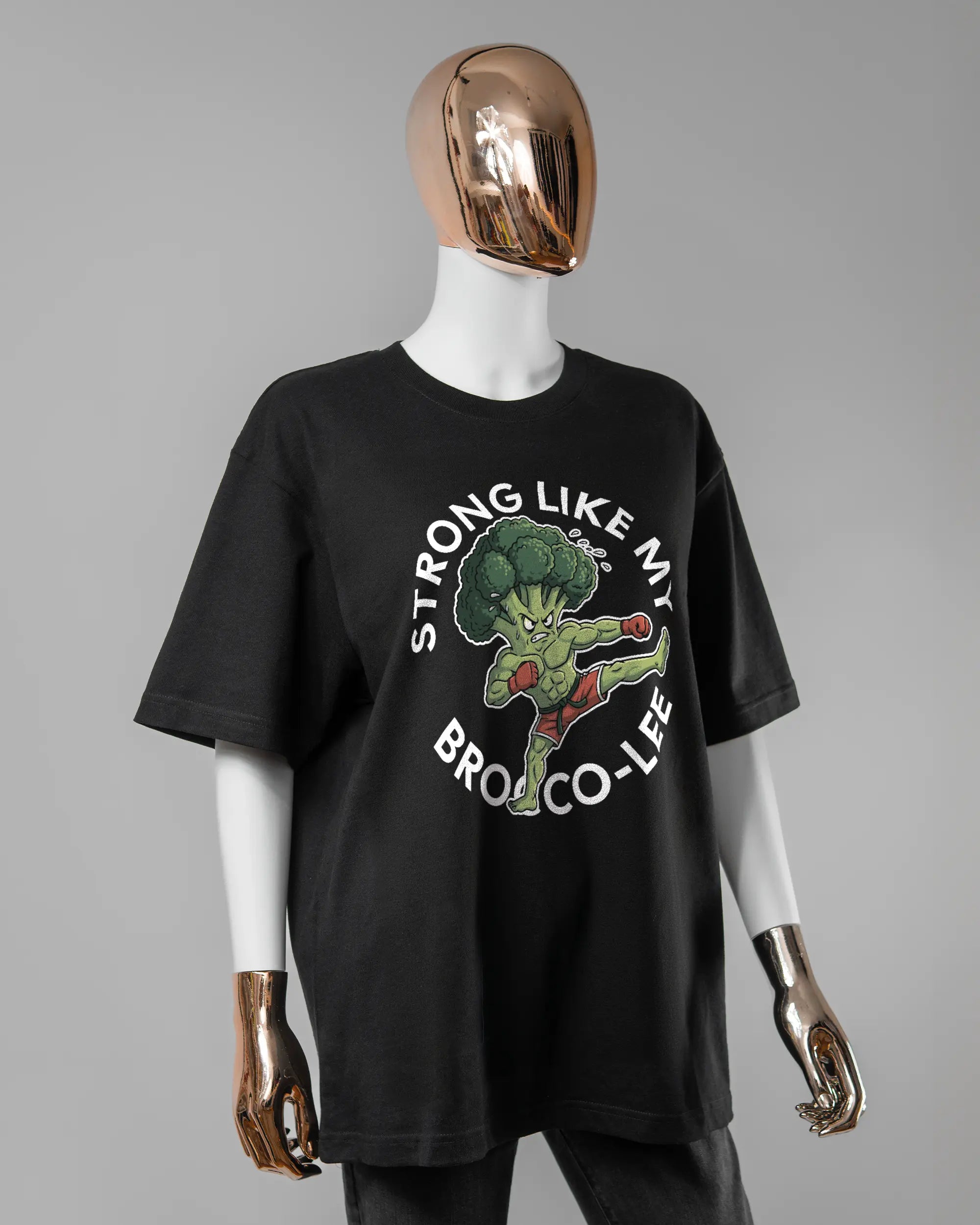 Vorderseite des Basic Unisex T-Shirt Oversized von Maondo mit dem Design Brocco-Lee in der Farbe Black und in der Größe S getragen von einer femininen Puppe