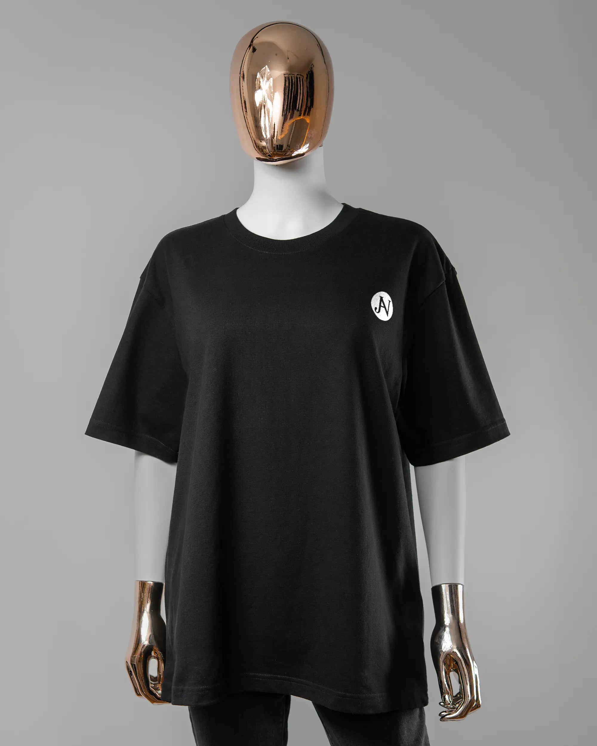 Vorderseite des Basic Unisex T-Shirt Oversized von Maondo mit dem Design JB1 in der Farbe Black und in der Größe S getragen von einer femininen Puppe