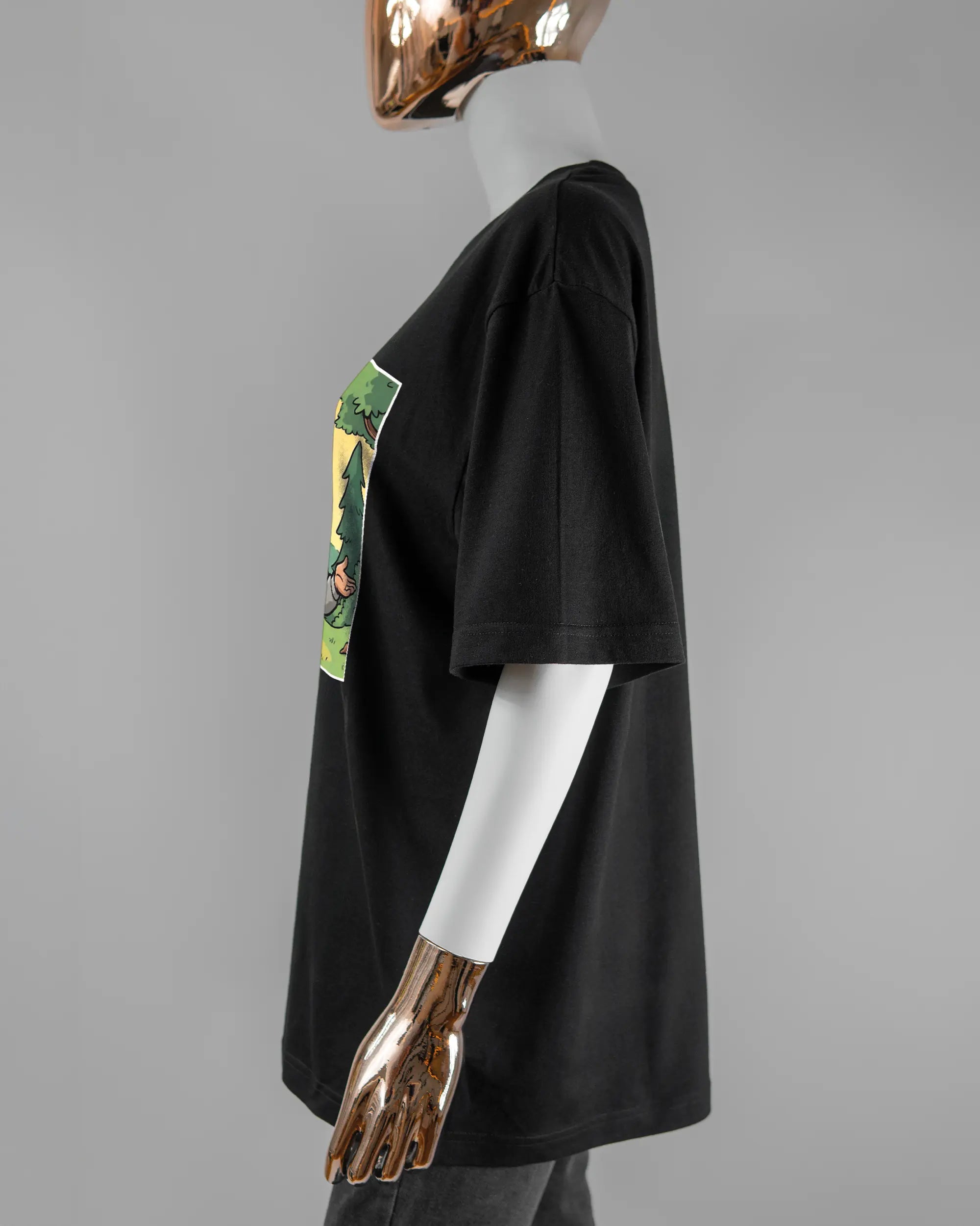 Seitenansicht des Basic Unisex T-Shirt Oversized von Maondo mit dem Design Vollspannung vorne in der Farbe Black und in der Größe S getragen von einer femininen Puppe