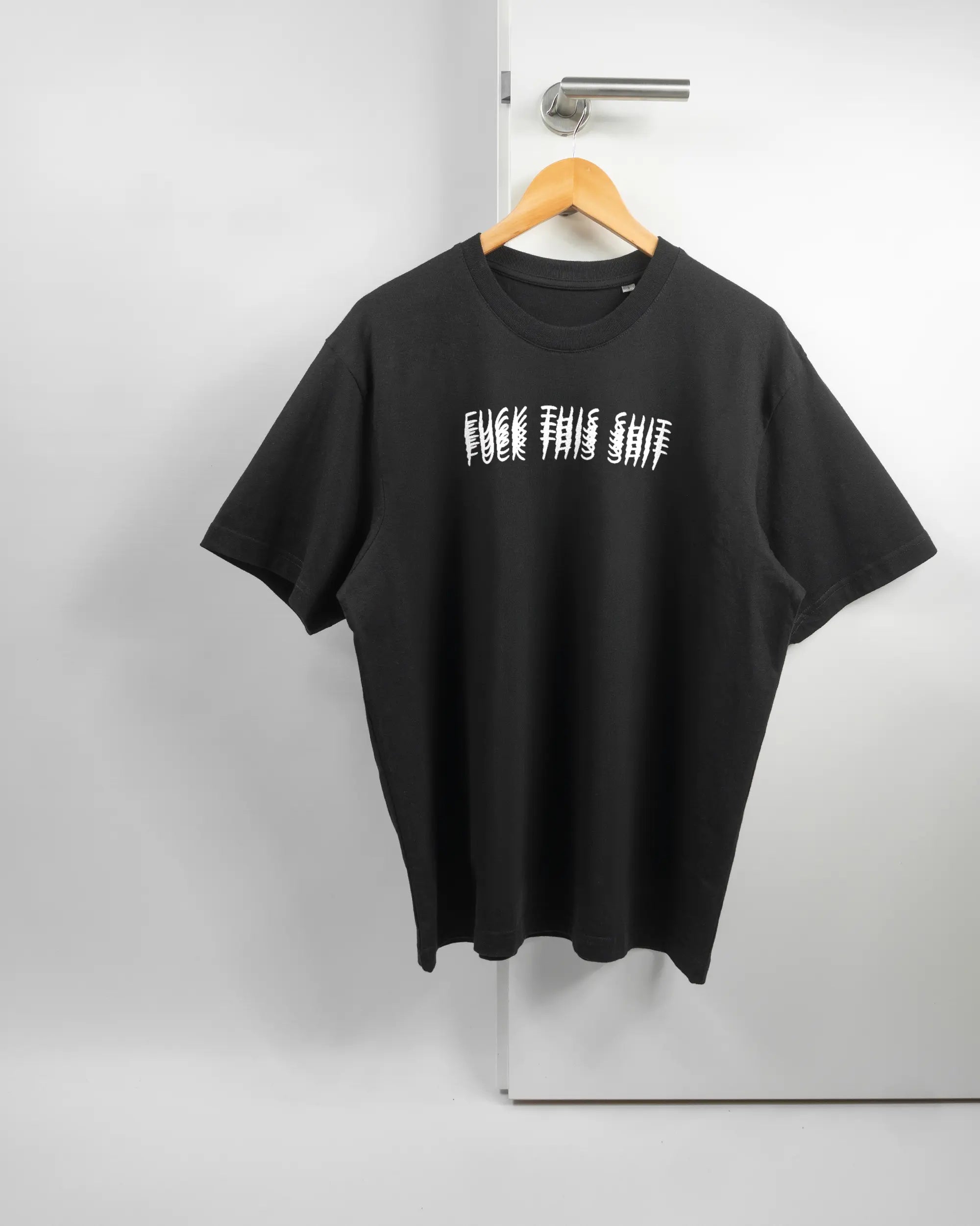 Vorderseite des Basic Unisex T-Shirt Oversized von Maondo mit dem Design Hidden Message in der Farbe Black und in der Größe S auf einem Bügel an der Türklinke aufgehängt