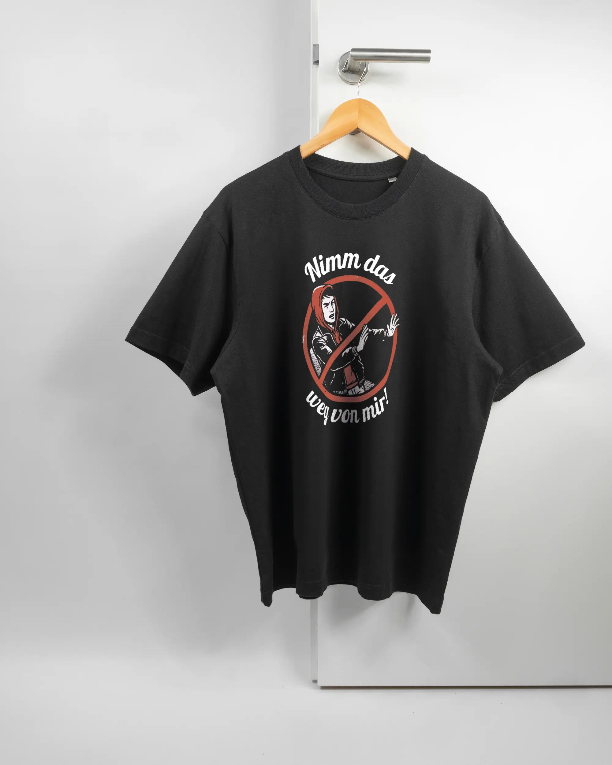 Vorderseite des Basic Unisex T-Shirt Oversized von Maondo mit dem Design Nimm das weg in der Farbe Black und in der Größe S auf einem Bügel an der Türklinke aufgehängt