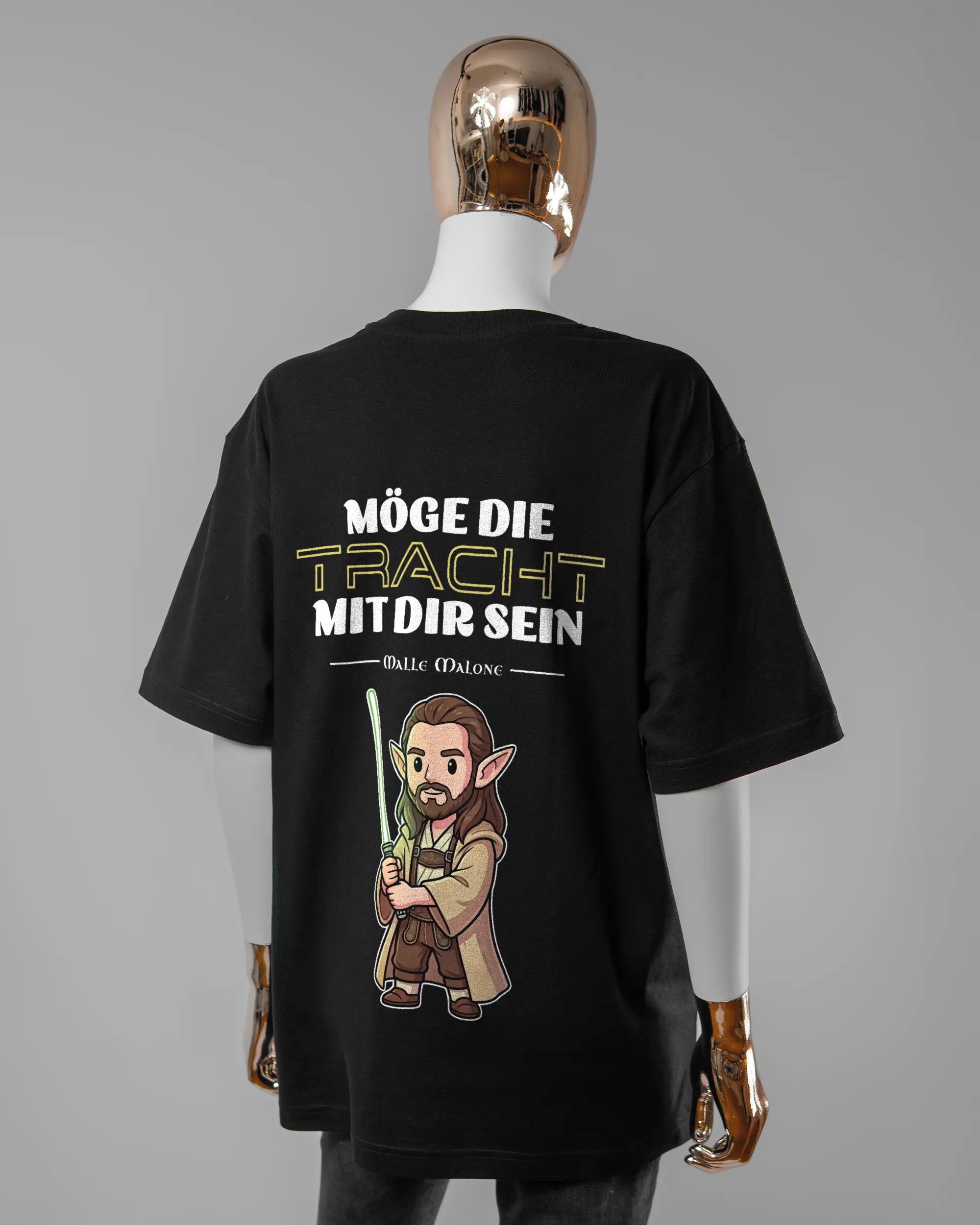 Rückseite des Basic Unisex T-Shirt Oversized von Maondo mit dem Design Tracht mit dir in der Farbe Black und in der Größe S getragen von einer femininen Puppe