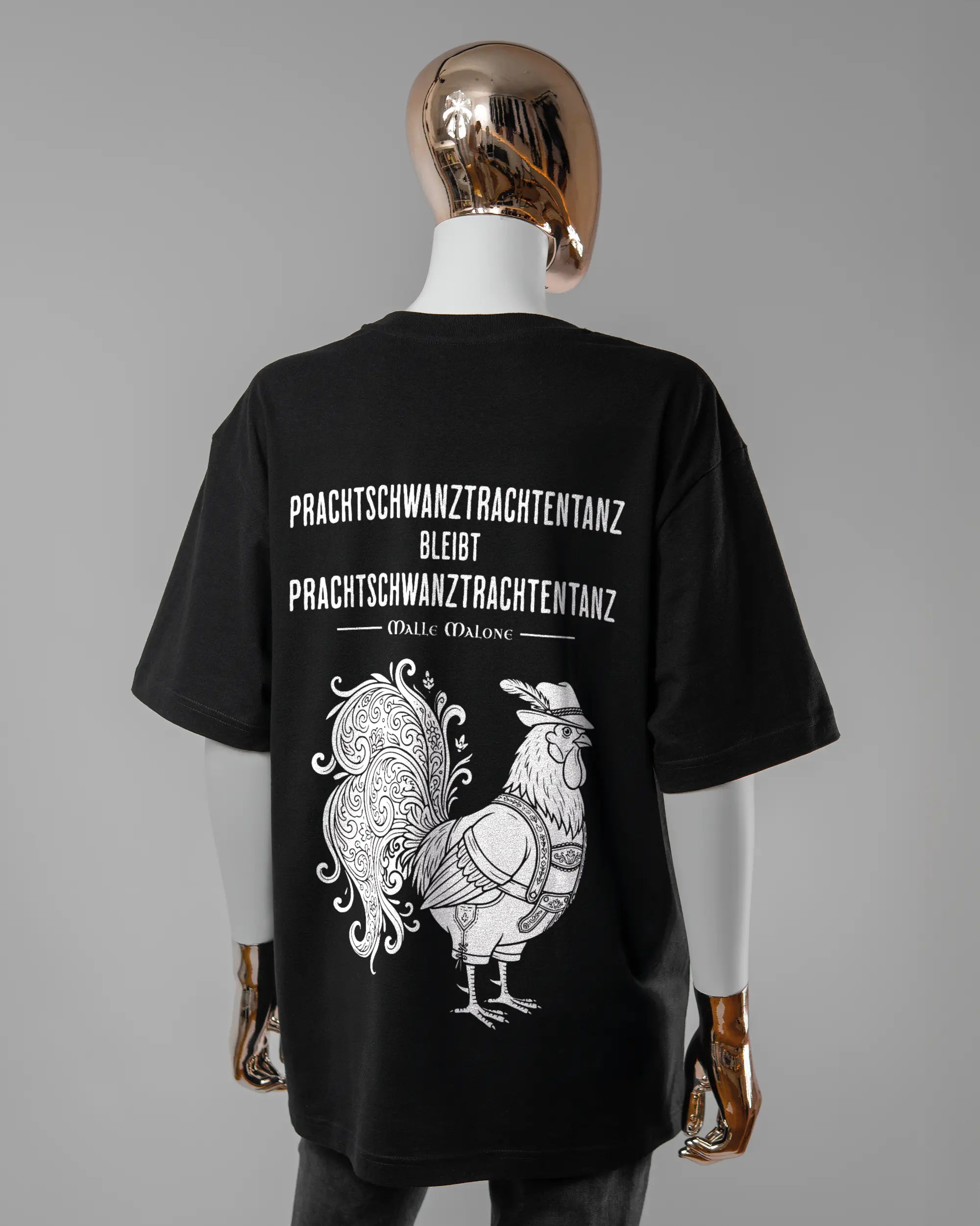 Rückseite des Basic Unisex T-Shirt Oversized von Maondo mit dem Design Trachtentanz in der Farbe Black und in der Größe S getragen von einer femininen Puppe