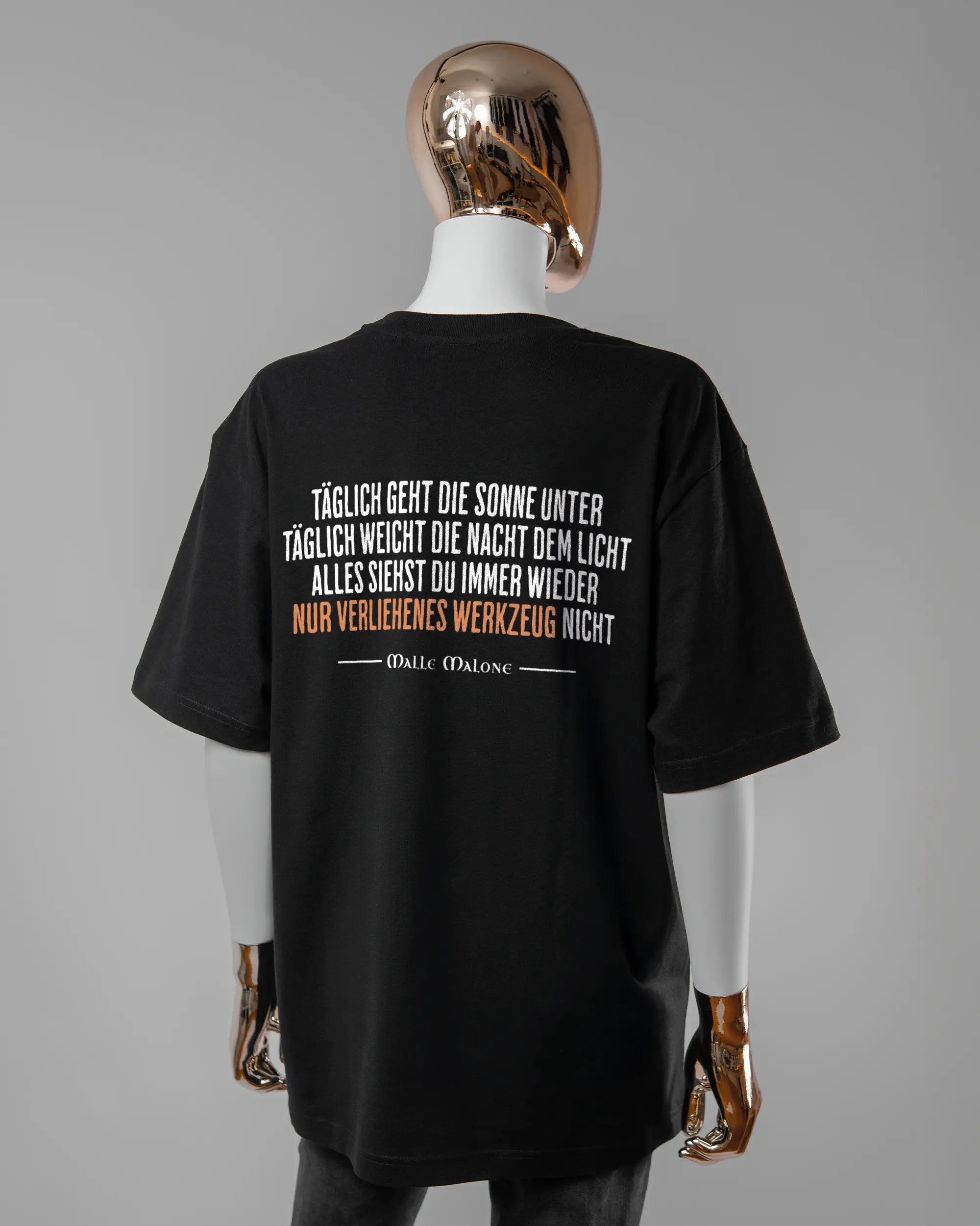 Rückseite des Basic Unisex T-Shirt Oversized von Maondo mit dem Design Wegzeug in der Farbe Black und in der Größe S getragen von einer femininen Puppe