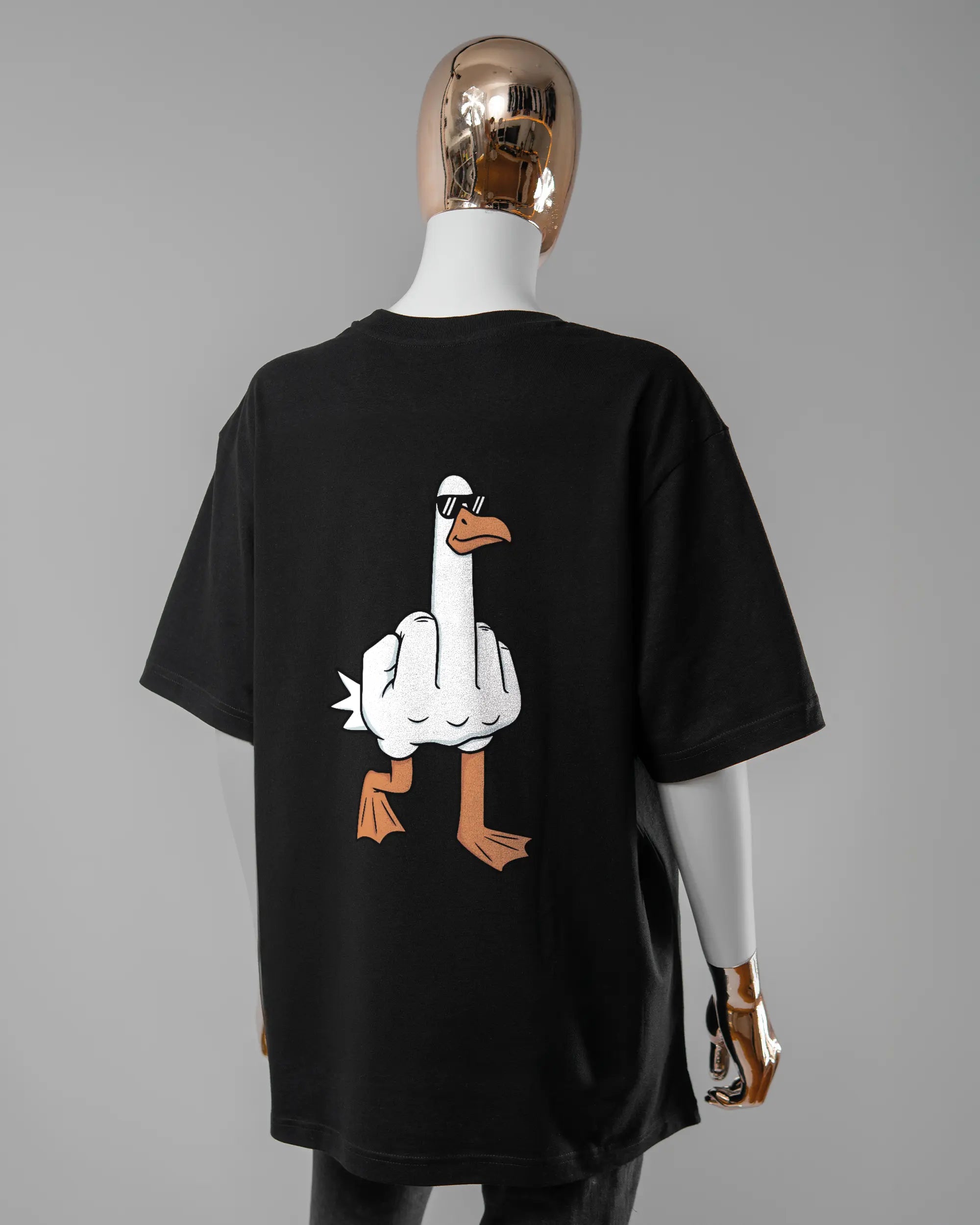 Rückseite des Basic Unisex T-Shirt Oversized von Maondo mit dem Design I give a duck in der Farbe Black und in der Größe S getragen von einer femininen Puppe