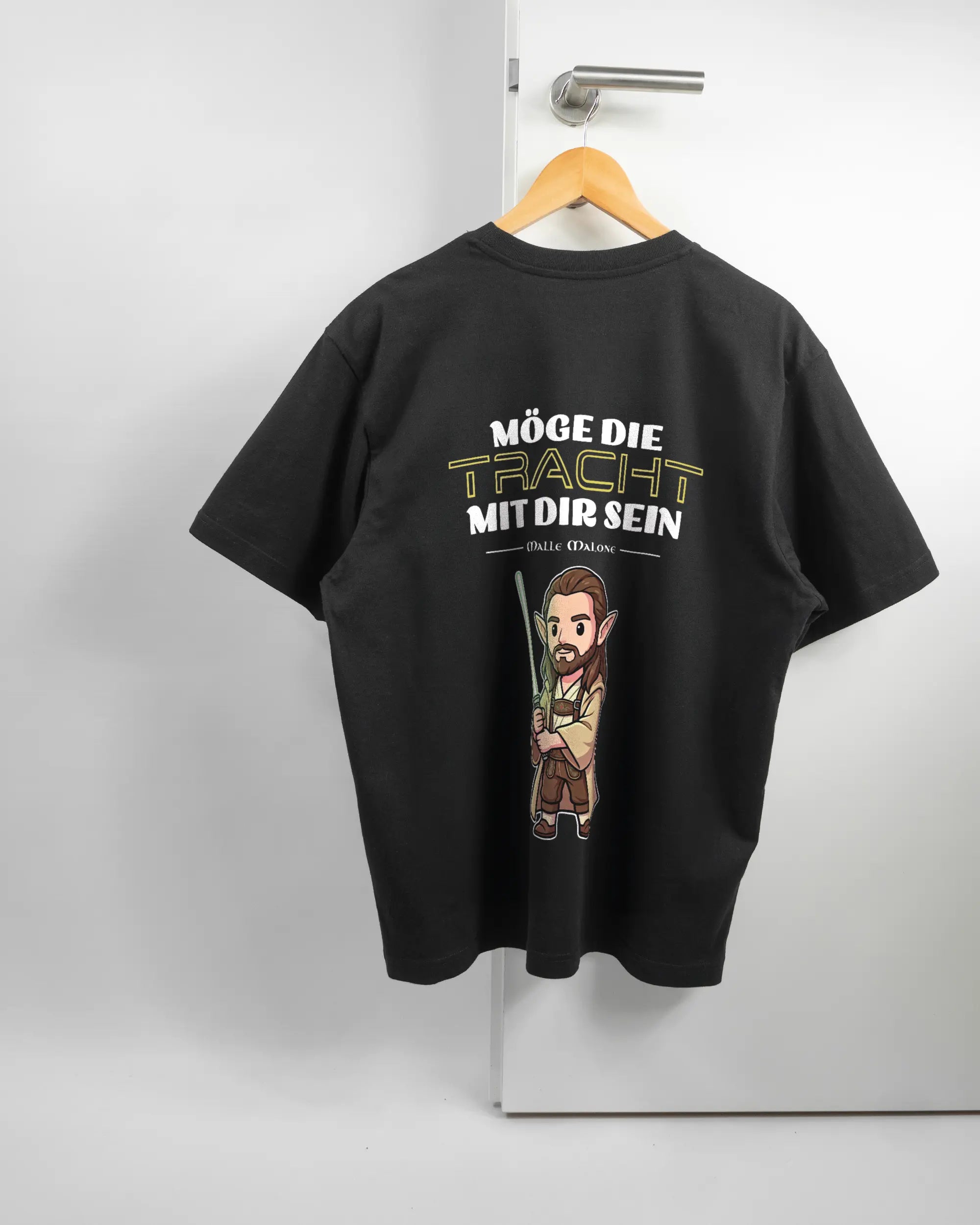 Rückseite des Basic Unisex T-Shirt Oversized von Maondo mit dem Design Tracht mit dir in der Farbe Black und in der Größe S auf einem Bügel an der Türklinke aufgehängt