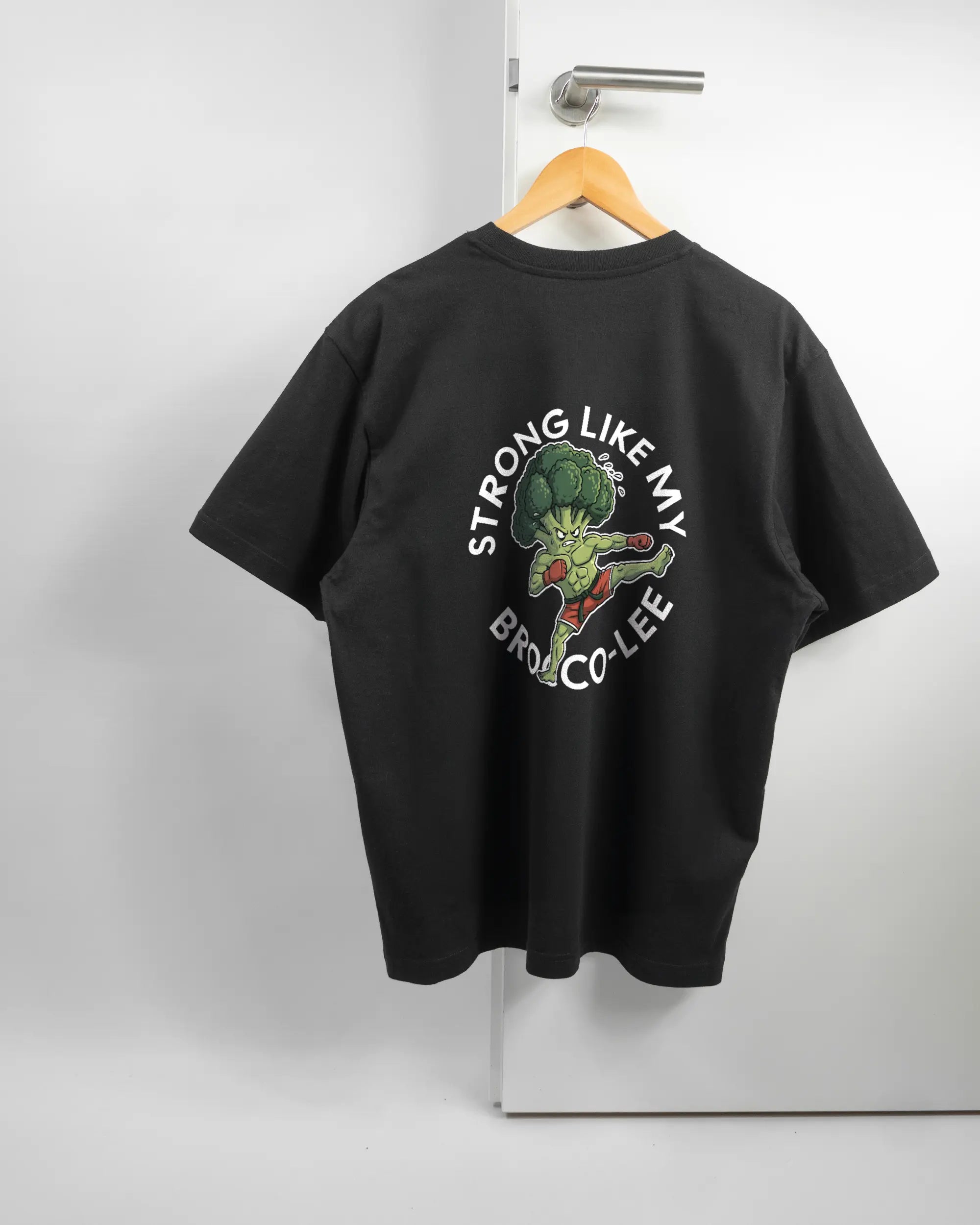 Rückseite des Basic Unisex T-Shirt Oversized von Maondo mit dem Design Brocco-Lee in der Farbe Black und in der Größe S auf einem Bügel an der Türklinke aufgehängt