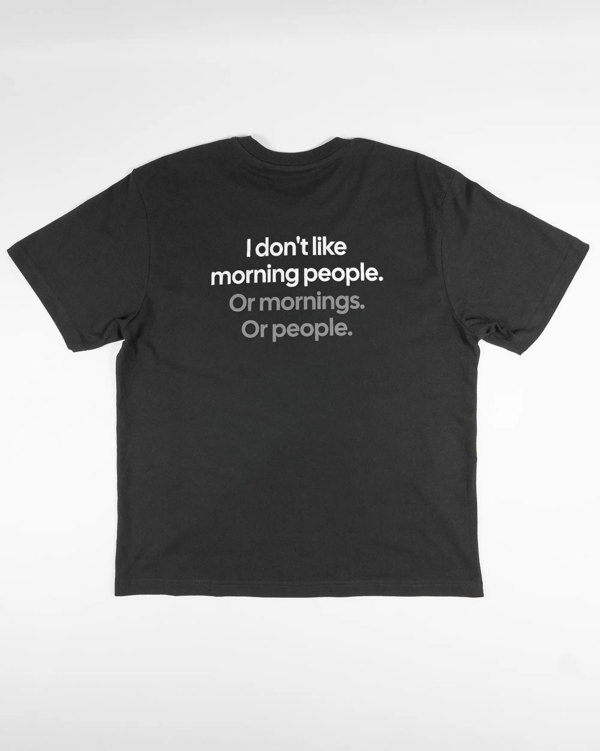 Rückseite des Basic Unisex T-Shirt Oversized von Maondo mit dem Design Morning Person in der Farbe Black und in der Größe S flach auf den Boden gelegt