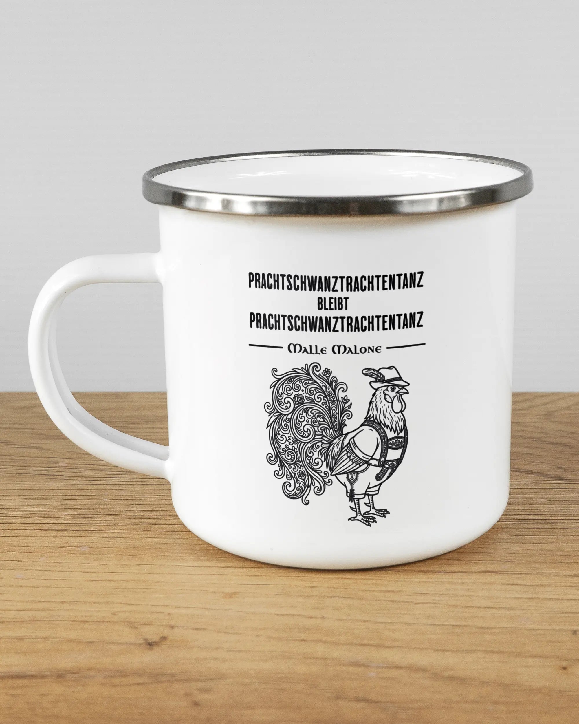 Titelbild, das die linke Seite der beidseitig bedruckten Emailletasse von Maondo mit dem Design Trachtentanz in der Farbe White-Silver auf einem Holztisch zeigt